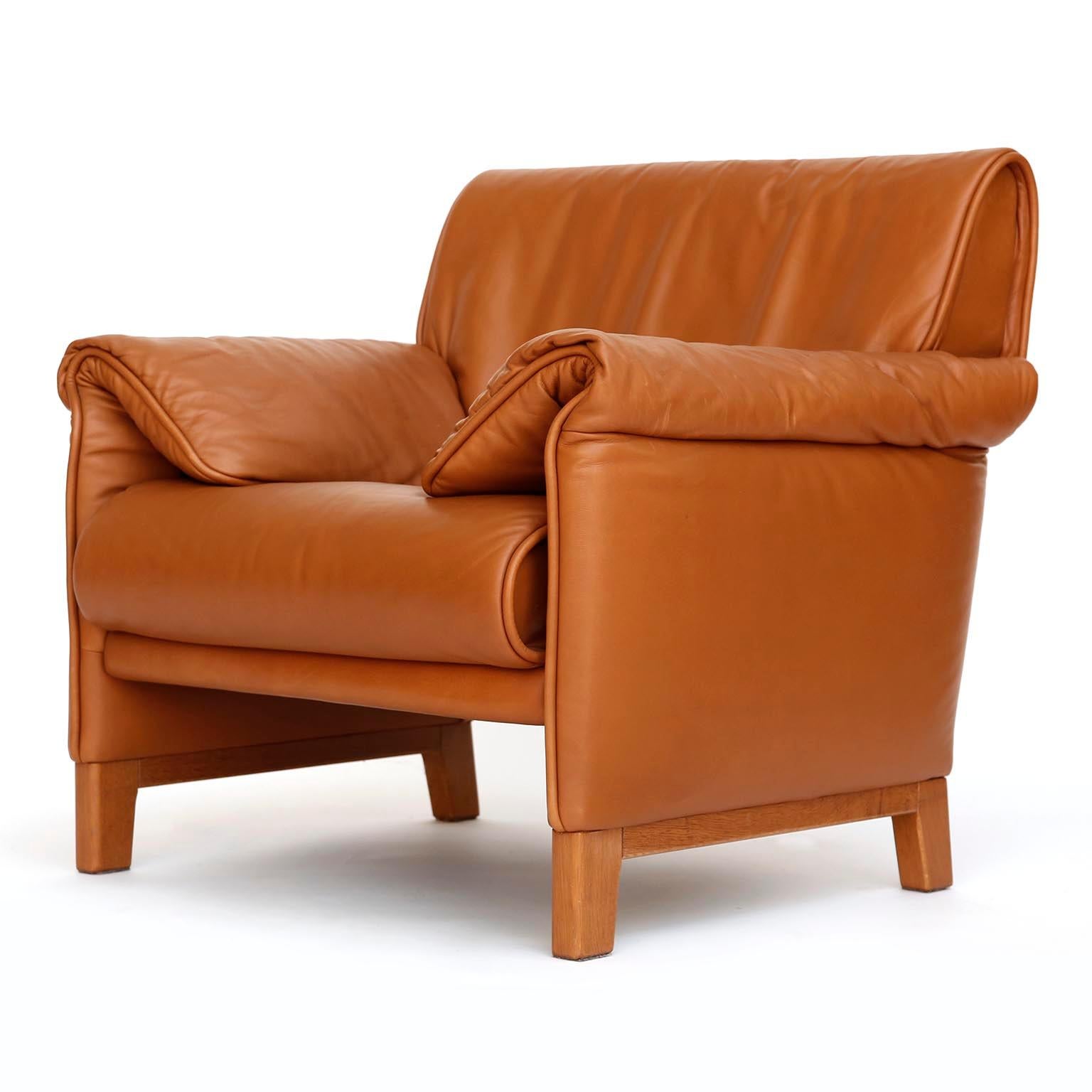 One of four De Sede 'DS-14' armchairs in a warm high quality cognac brown leather with a solid Teak base, designed in 1989 and manufactured between 1989 and 1997.
The chairs are in great and almost new condition. They are labeled inside with De