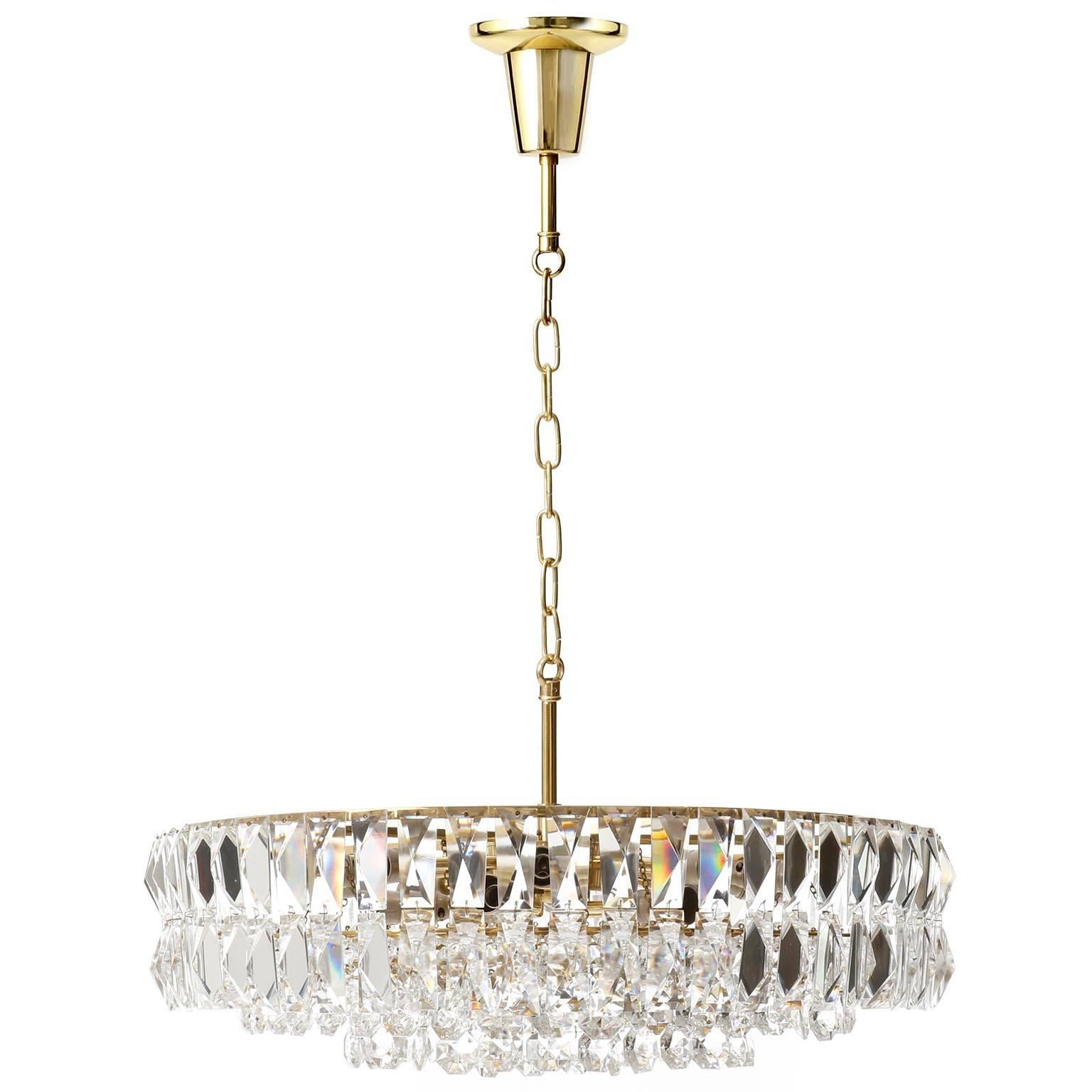 A large and high quality crystal glass chandelier designed by J.T. Kalmar, Vienna, manufactured in Mid-Century, circa 1960 (late 1950s or early 1960s).
It is made of a brass frame which is decorated with hand-cut crystal hanging elements. This light