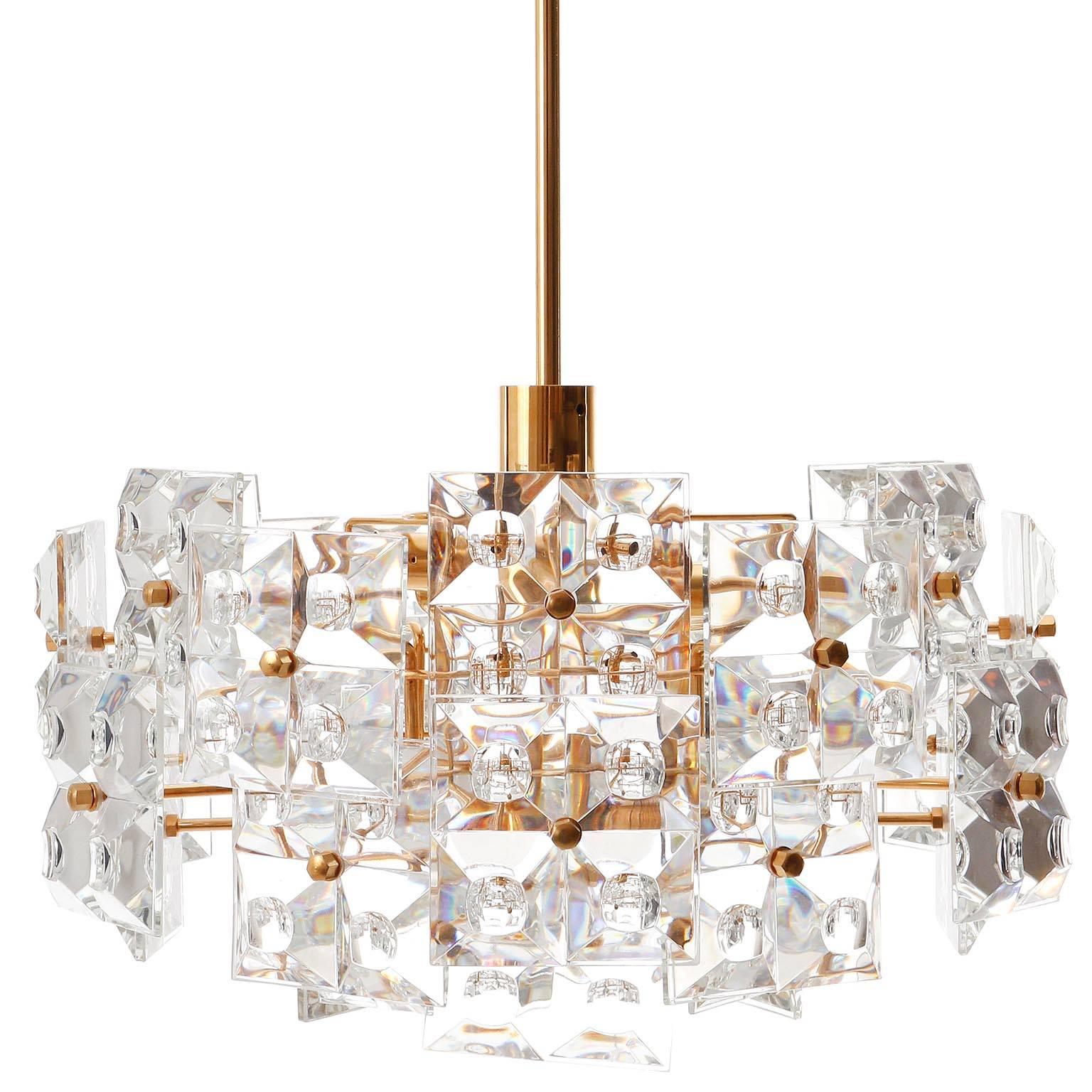 A very exclusive and high quality chandelier by Kinkeldey, Germany, manufactured in mid-century, circa 1970 (late 1960s or early 1970s). It is made of a gilded / gilt frame which holds large cut crystal glass with the dimensions of 4 x 4 in. (10 x