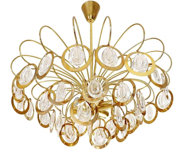 A wonderful multi-tiered glass and brass chandelier in the style of Sciolari, Italy, manufactured in midcentury, circa 1970, (late 1960s-early 1970s).
It is made of gilt brass and glasses in the form of lenses.
The lamp has six sockets for E14