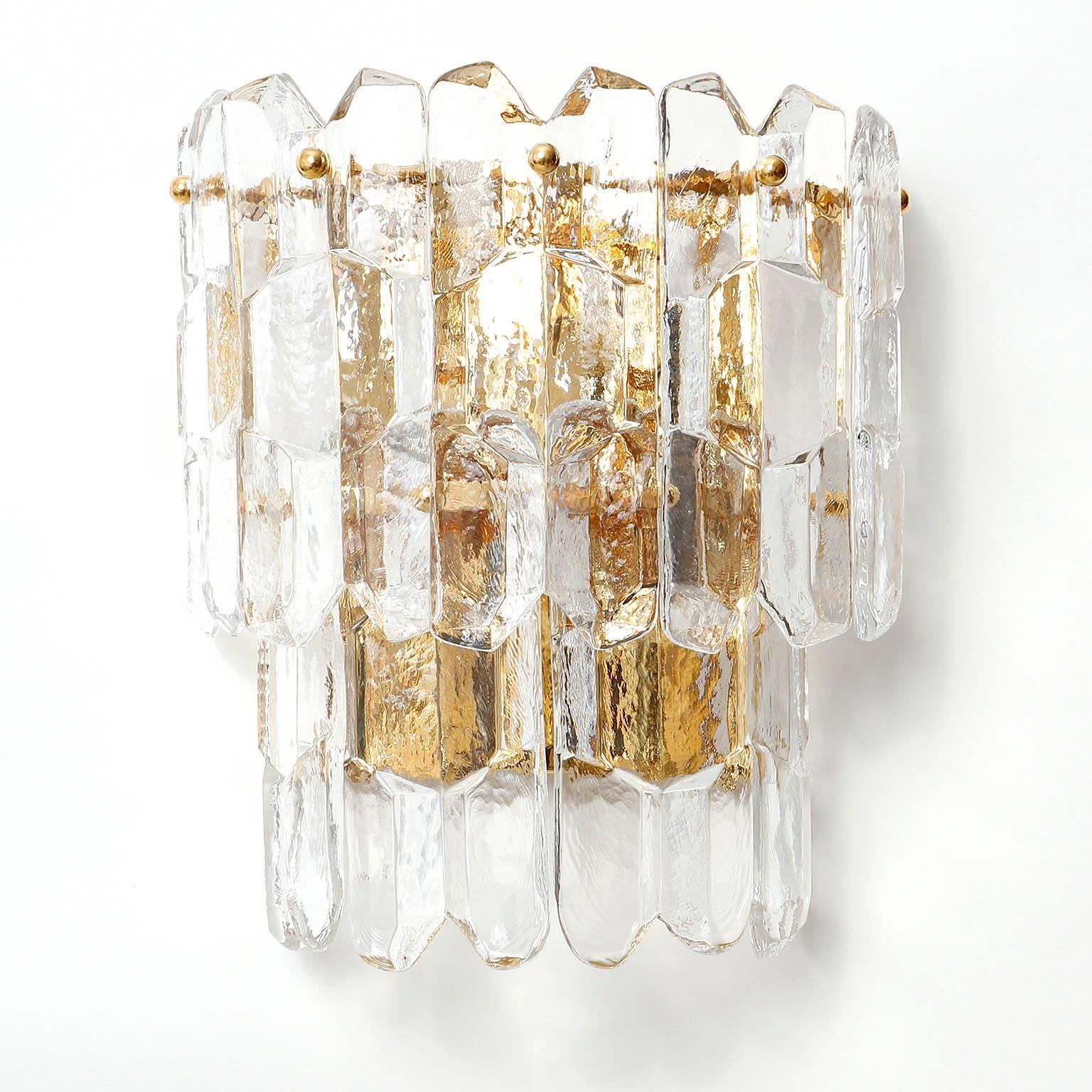 A pair of very exquisite 24-carat gold-plated brass and clear brilliant glass 'Palazzo' wall lights by J.T. Kalmar, Vienna, Austria, manufactured in circa 1970 (late 1960s and early 1970s).
These large Hollywood regency lamps are handmade and high