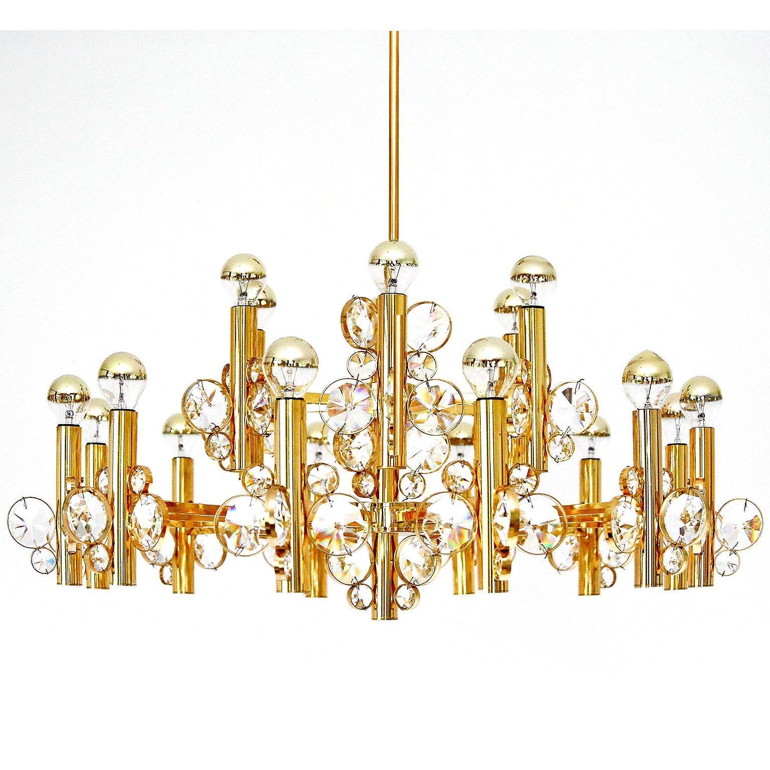 Very impressive eighteen-arm chandelier in the style of Bakalowits, Palwa or Sciolari, manufactured in Mid-Century (1960s - 1970s), ca. 1970. It is made of a gilded frame and diamond shaped crystals. 
The light has 18 sockets for small Edison screw
