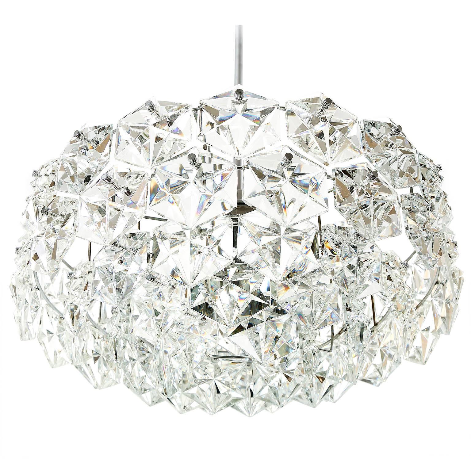 A high quality chandelier by Kinkeldey, Germany, manufactured in Mid-Century, circa 1960.
It is made of a nickeled or chromed brass frame and hexagonal sahped crystal glass.
The light has seven sockets in total. Six sockets for small screw base