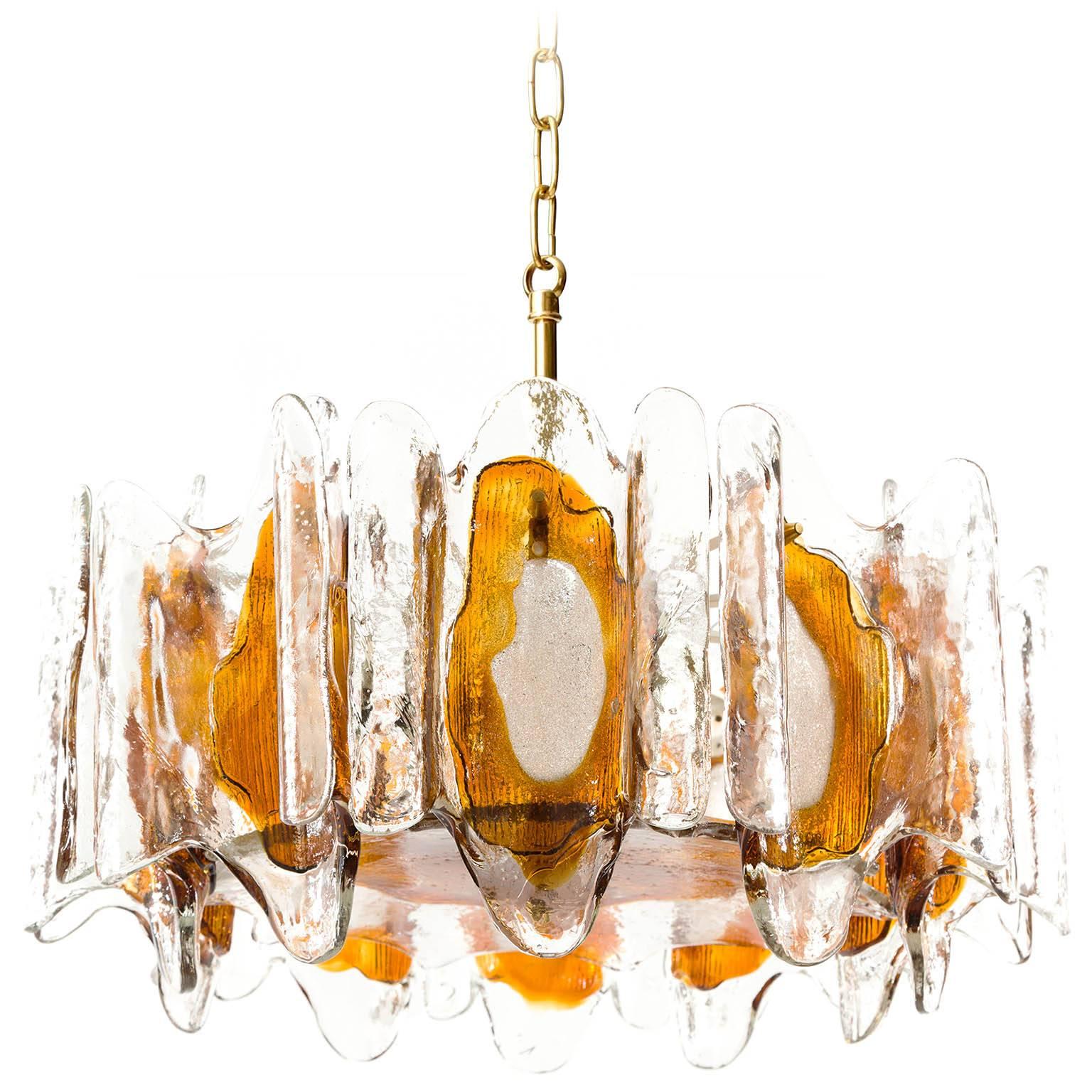 A beautiful pendant chandelier made of melted orange / amber tone Murano glass by Kalmar, manufactured in midcentury, circa 1970 (late 1960s or early 1970s).
The light fixture has five sockets for small screw base bulbs or LEDs.
The lights can be
