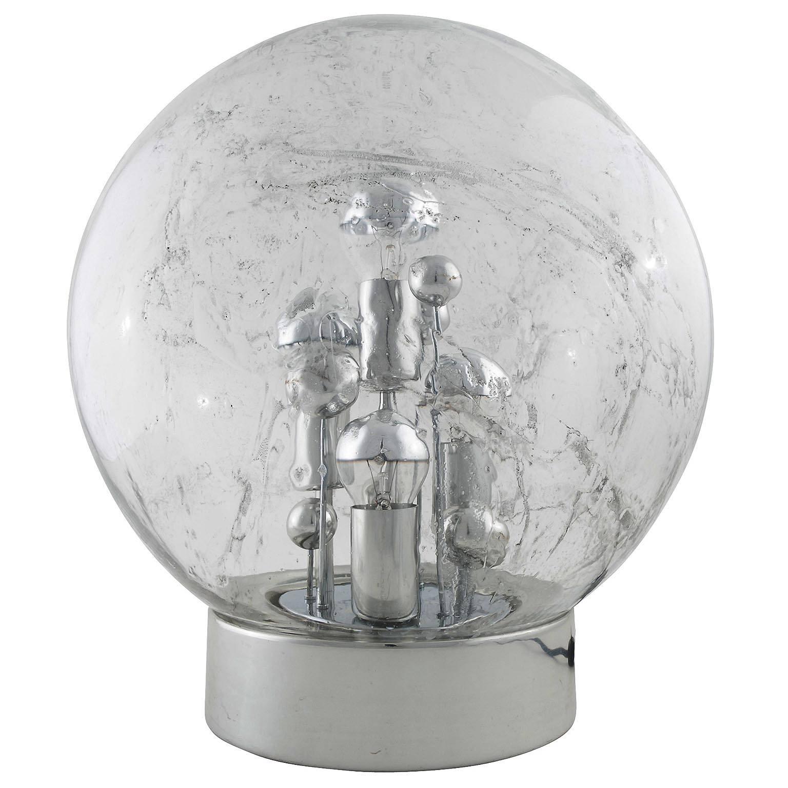 A table or floor lamp by Doria Leuchten Germany from the 1970s. A large smoked glass globe with many air bubble inclusions and a chromed base.
The light has four sockets of medium base bulbs (60W max. per bulb). Works well with mirrored half chrome