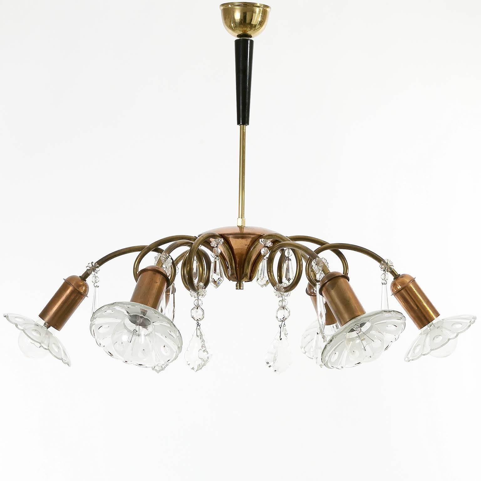 A Mid-Century Modern six-arm chandelier by Rupert Nikoll, Vienna, 1950s.
It is made of cut-glass, natural aged copper and brass. The rod is covered by ebonized wood. 
The piece is decorated with a lot of cut glass pieces.