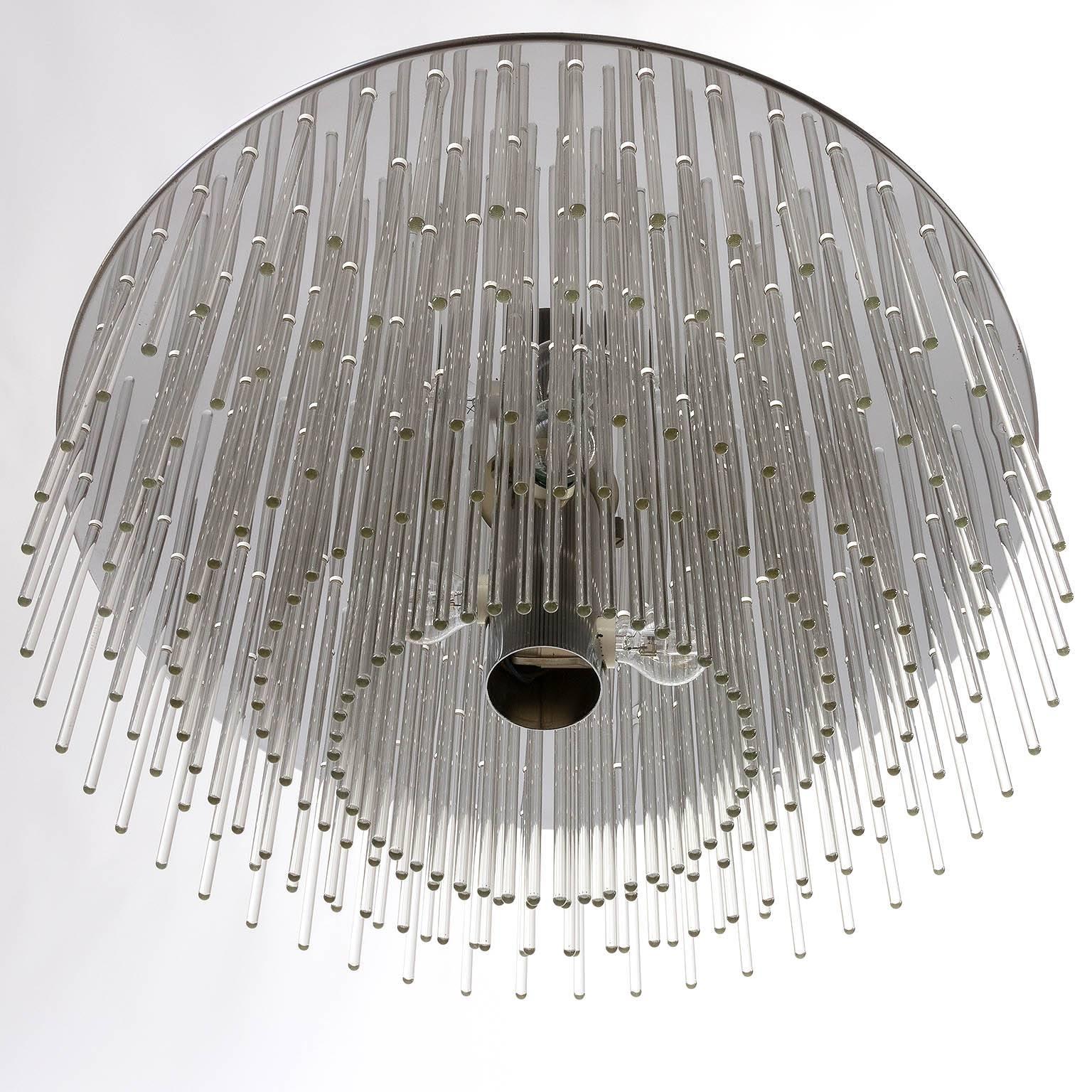 A wonderful Italian multi-tiered flush mount chandelier with varying sized handblown glass rods inserted into the chrome disc. Manufactured in Mid-Century, circa 1970 (late 1960s or early 1970s). 
The light fixture is wired for US junction boxes. It