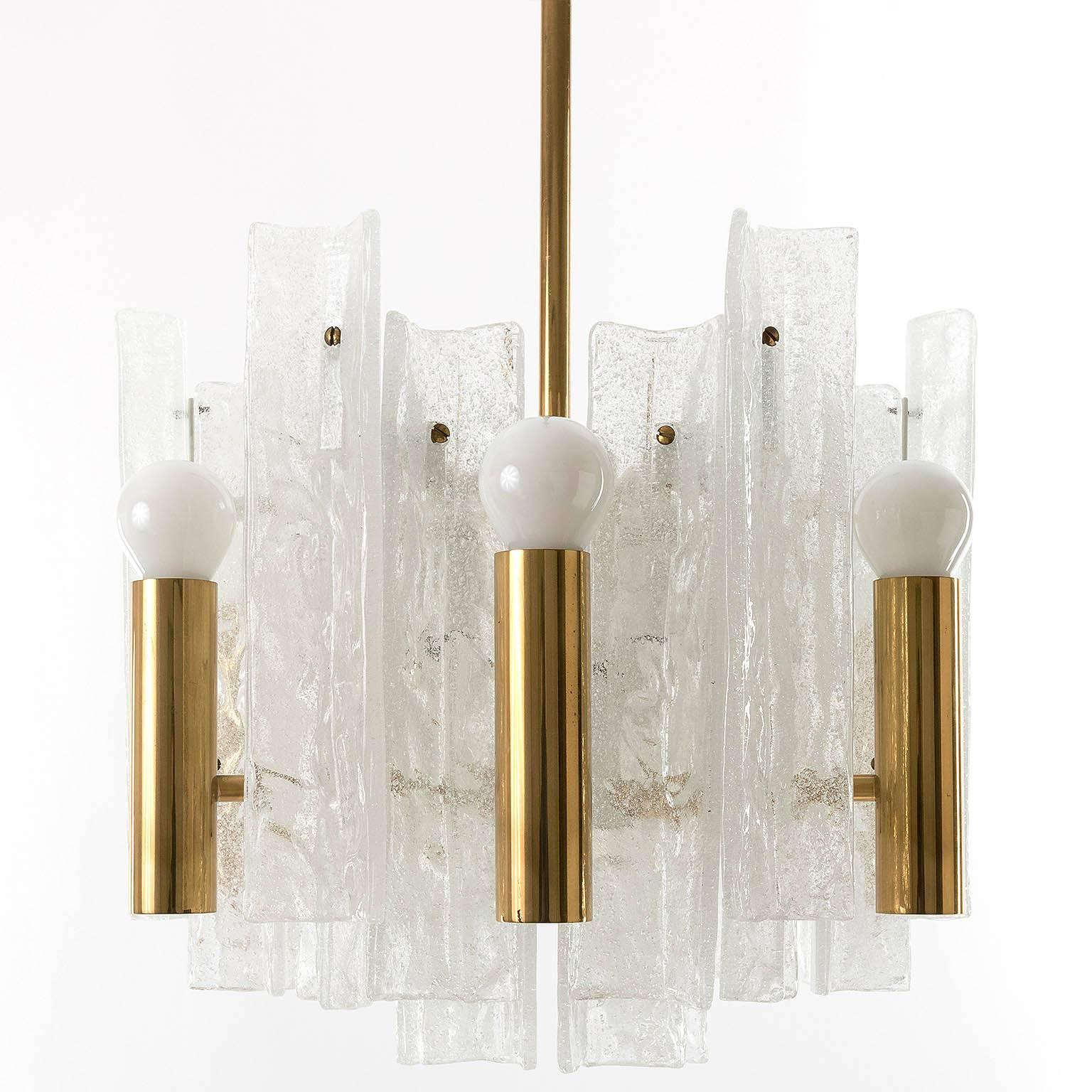 Beautiful chandelier made of brass and textured foamglass by Kalmar. Twelve small base bulbs (six upwards and six downwards directed). Works well with different kind of bulbs (clear, frosted or half gold mirror bulbs).

Measures: Diameter 14.2 in