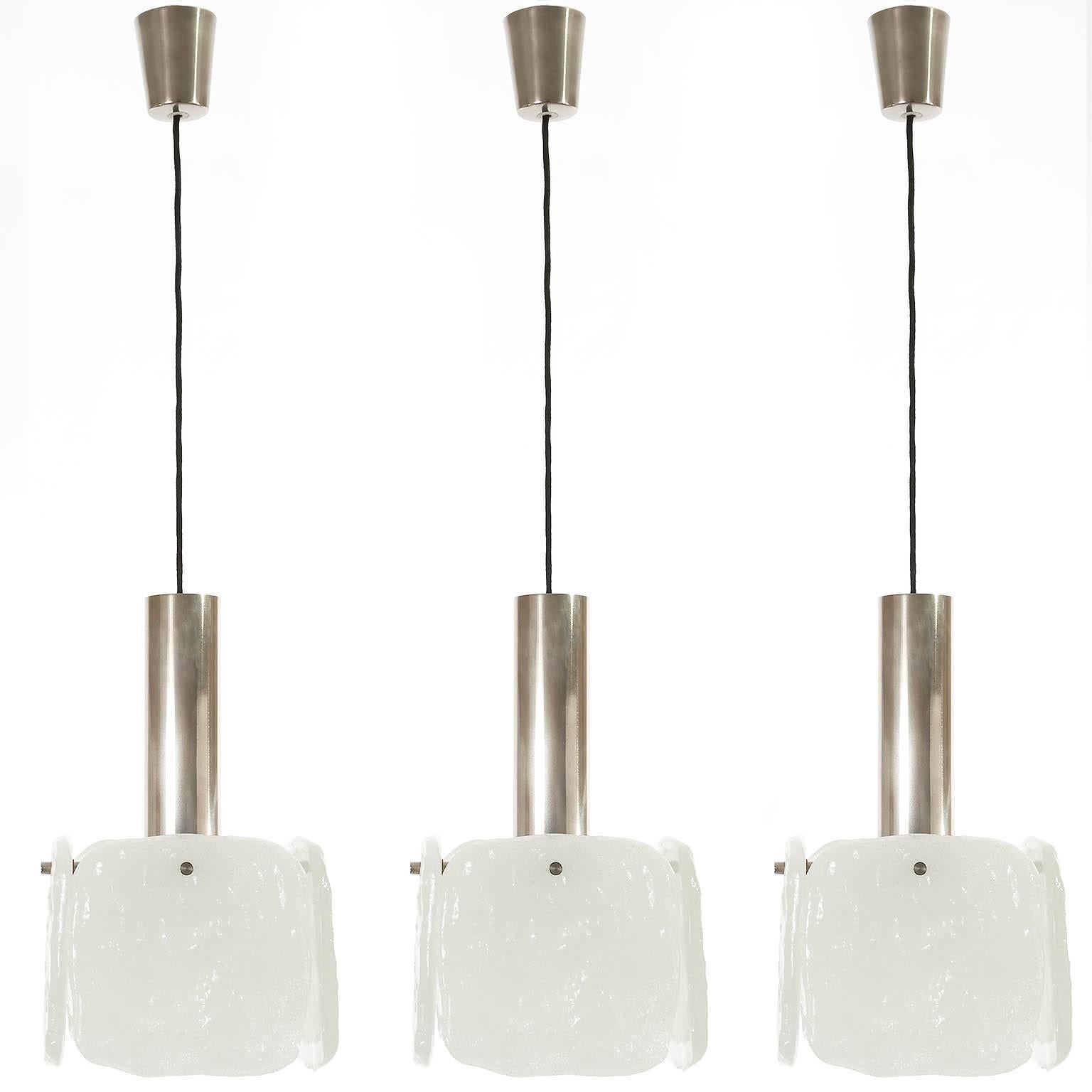 Only one light is available.
One of three pendant lamps by Kalmar, Austria, 1960s. They are made of frosted glasses and chrome (or nickel) plated brass. One medium screw base bulb per light. 
The total drop can be altered to any length for free. US