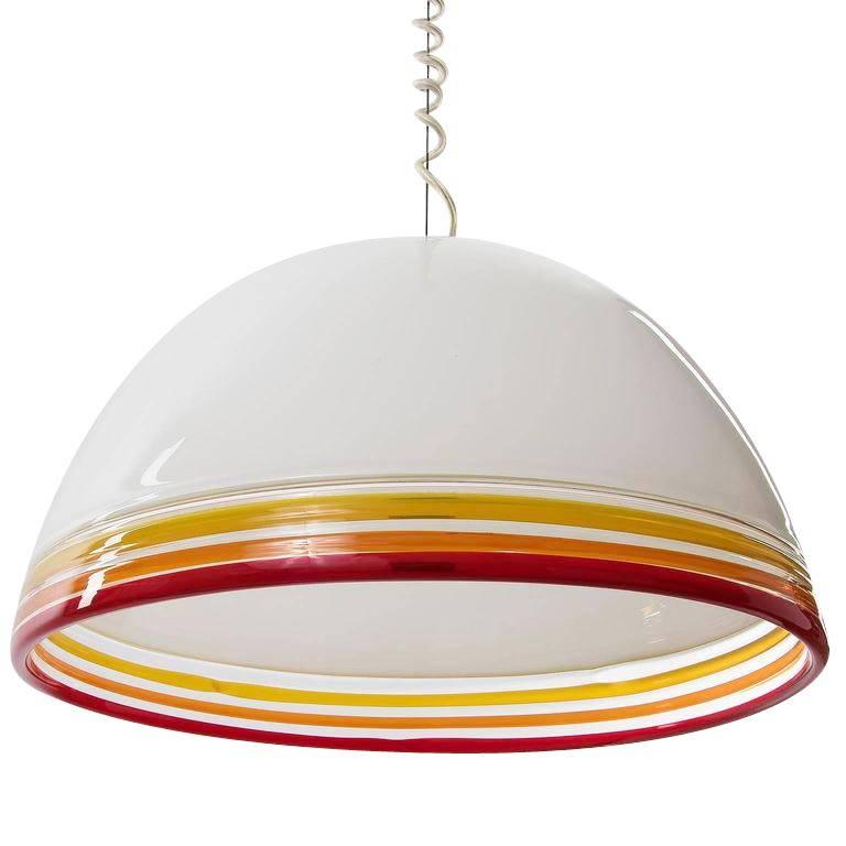 A pendant light fixture designed by Roberto Pamio and Renato Toso for Leucos, Italy, manufactured in Mid-Century, circa 1975.
It is made of an opal white handblown Murano glass shade with three different colored (red, orange, yellow) rings. One