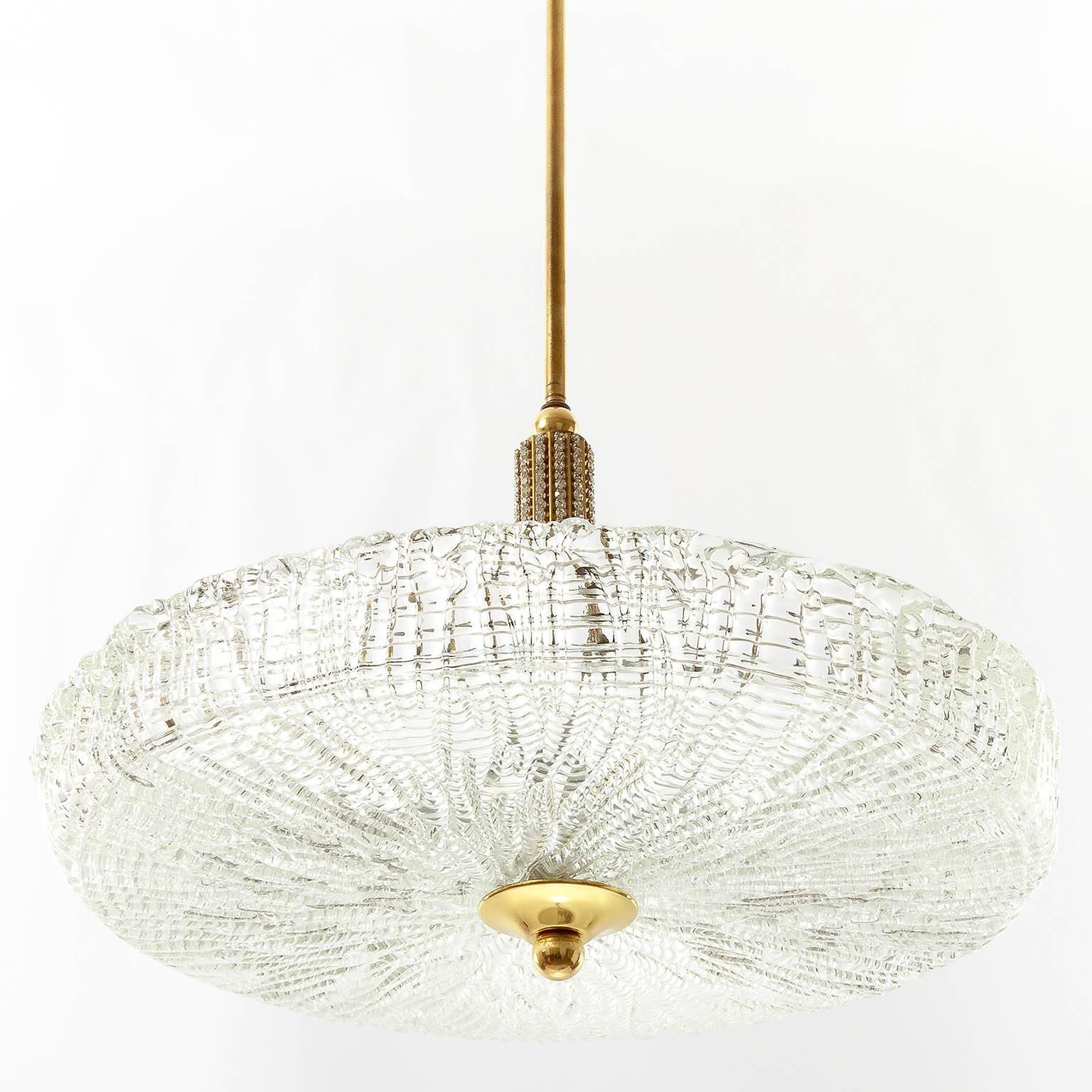 A beautiful chandelier made of textured glass, brass and small crystals. It is in the style of Austrian makers like Nikoll, Kalmar and Bakalowits or Swedish maker Orrefors (Carl Fagerlund).

Six small base bulbs (max. 40W each). Flat and wide US