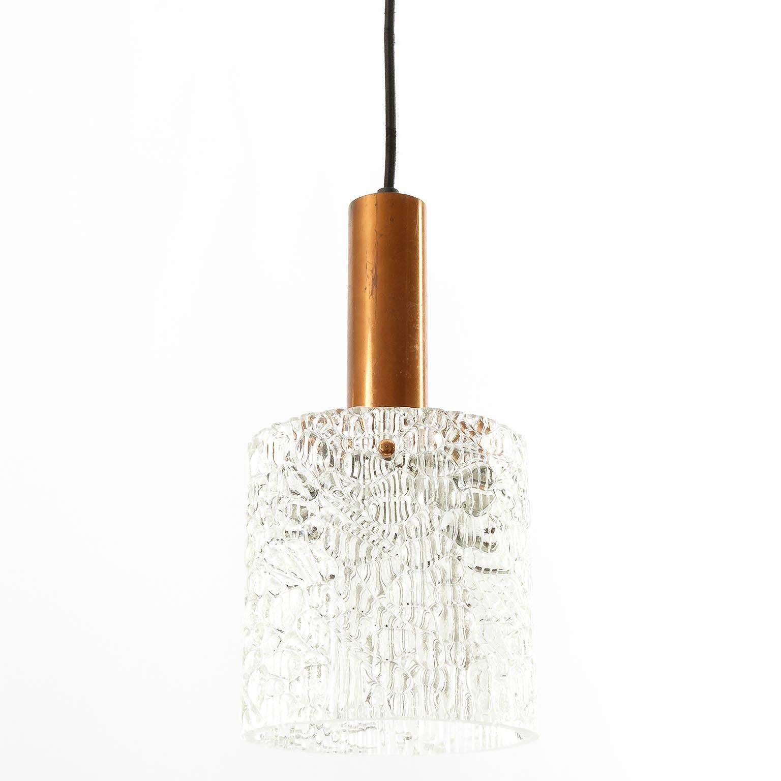 One of six pendant lights by Kalmar, Austria, manufactured in the 1950s. A textured glass zylinder is hold by a natural patinated mounting fixture. The glasses are in excellent condition, partially strong patina on copper. Copper can be repolished