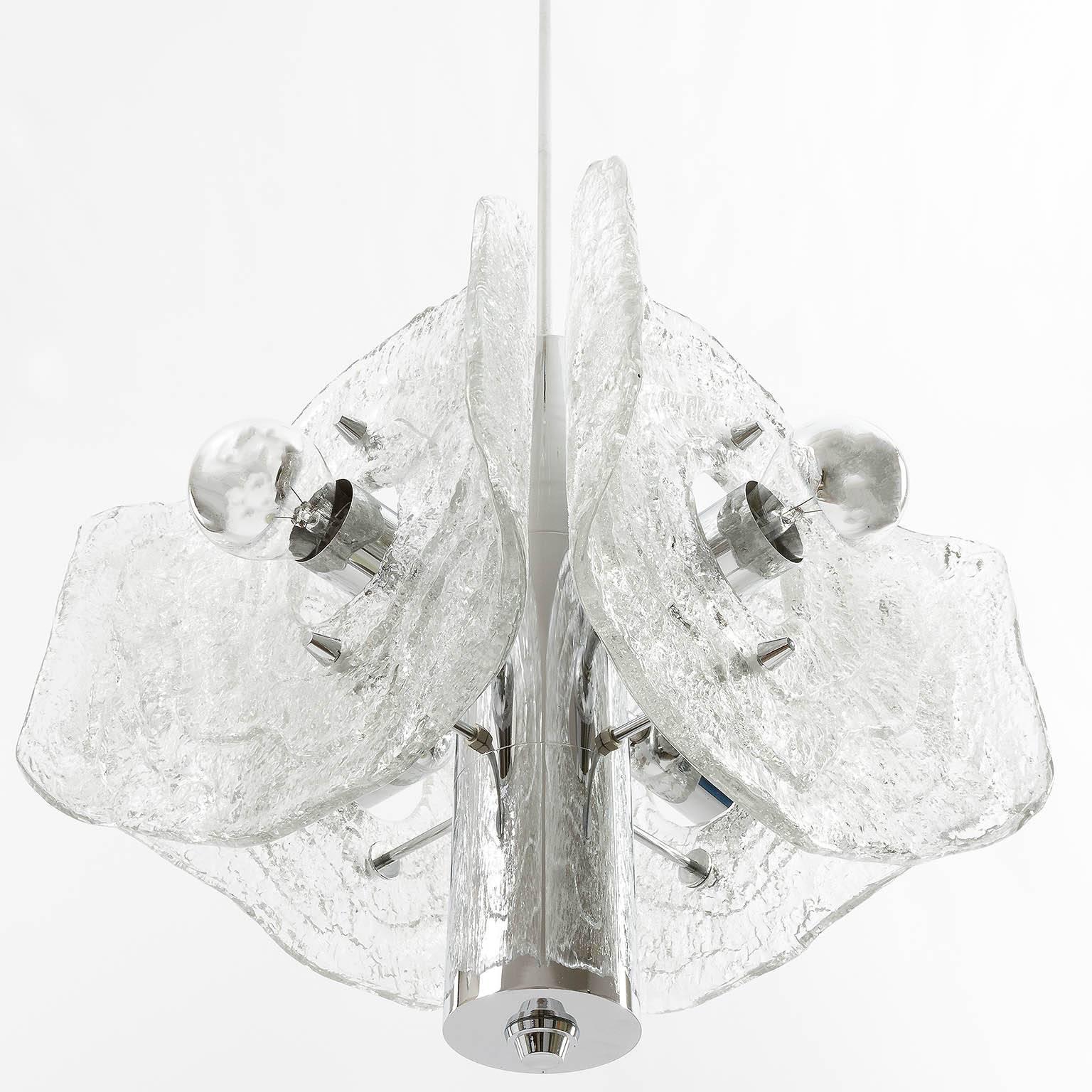 A Mid-Century chandelier / pendant light by Kalmar, manufactured in the 1970s. A chrome frame holds four frosted glasses in the form of leaves. It takes four medium screw base bulbs and works well with mirrored or clear bulbs. 

Diameter: 20