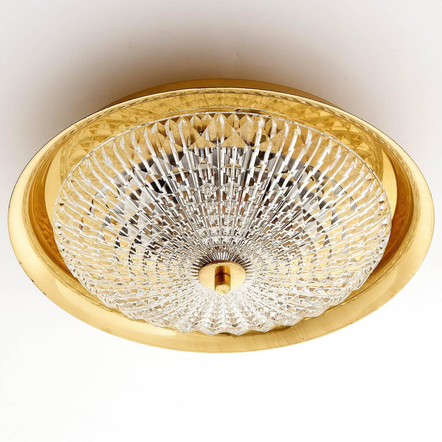 A beautiful Scandinavian modern brass and textured glass light fixture by Carl Fagerlund for Orrefors/Lyfa, Sweden, manufactured in Mid-Century, circa 1960. 
The light has five sockets for small screw base E14 candelabra bulbs. 
It can be used as