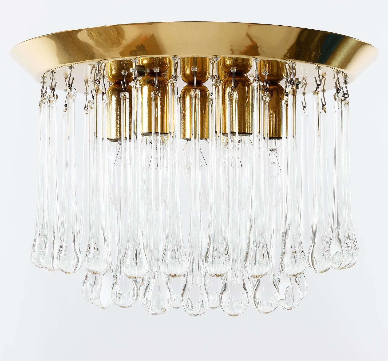 A rare and handmade high quality light fixture by J.T. Kalmar, Austria, manufactured in Mid-Century, circa 1970 (1960s-1970s). It is made of polished brass and teardrop shaped crystal glasses. It takes seven small base bulbs (max. 40 W per bulb).