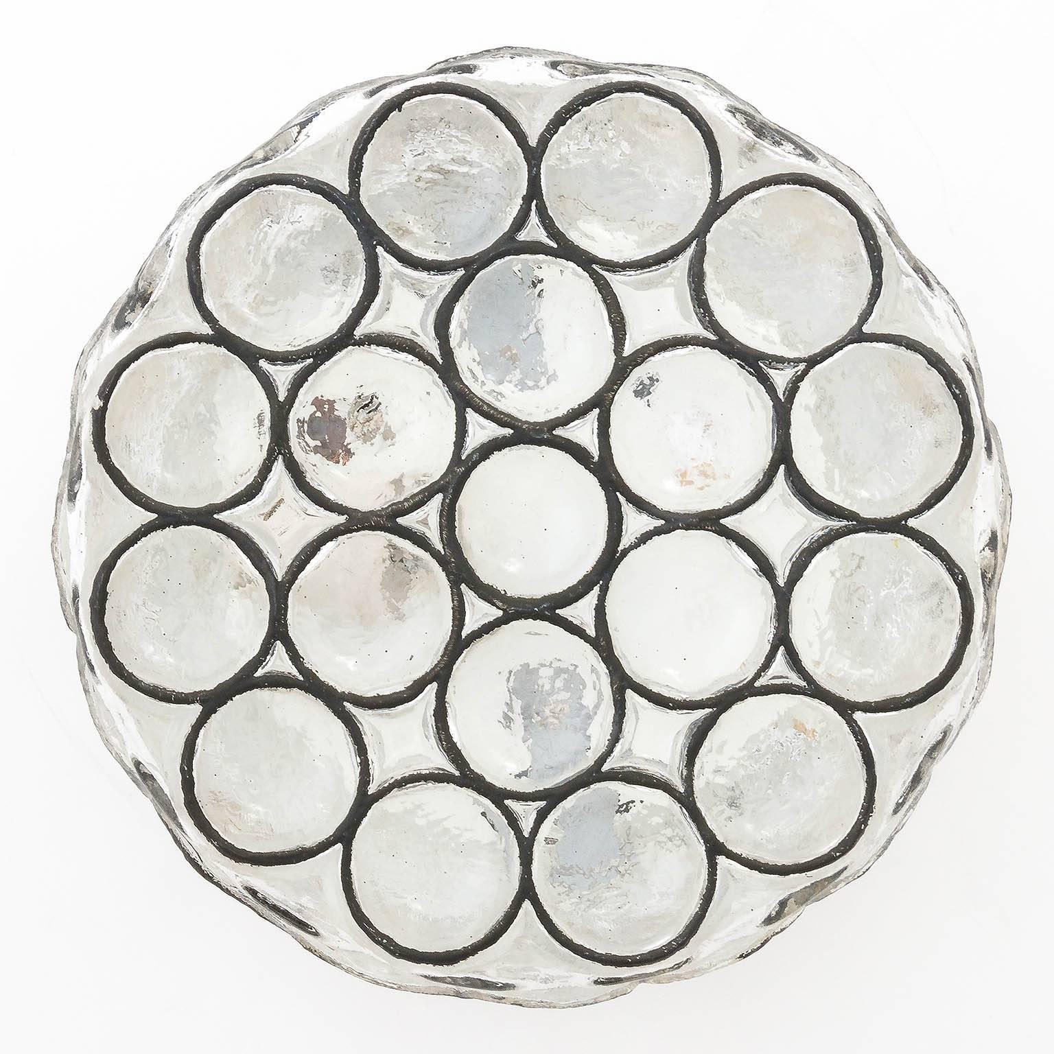 Beautiful and unique design 'iron' glass light fixture by Glashütte Limburg, Germany, manufactured in Mid-Century (1960s / 1970s). Can be used as wall or ceiling lamp. Black iron circles inlaid in thick clear glass. Labeled.
One medium base bulb