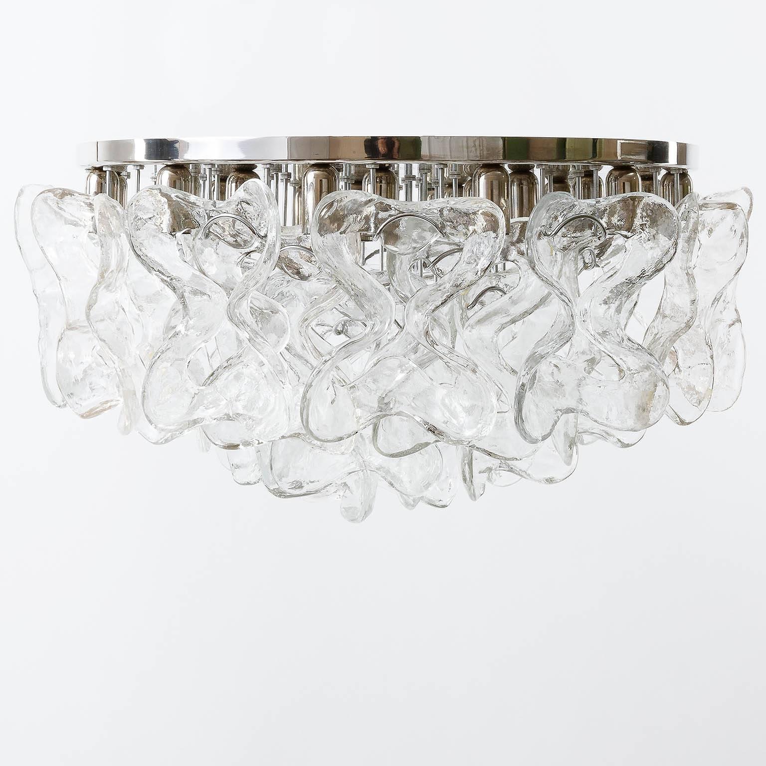 A fantastic light fixture model "Catena" by J.T. Kalmar, Austria, manufatured in Mid-Century (1970s-1980s). It is made of a chromed backplate with 30 Murano glass elements. Each glass measures 8" x 6" (20 x 15 cm). It takes 24