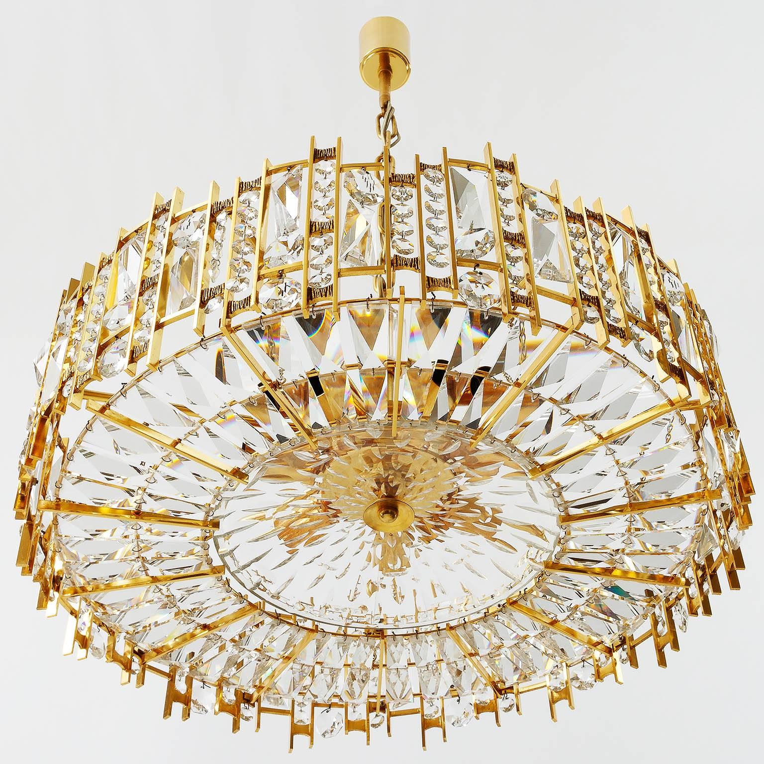 A fantastic and high quality gilded chandelier / pendant light fixture by Palwa (Palme & Walter), Germany, manufactured in Mid-Century, circa 1970 (late 1960s or early 1970s).
This hollywood regency lamp is made of a gold-plated brass frame