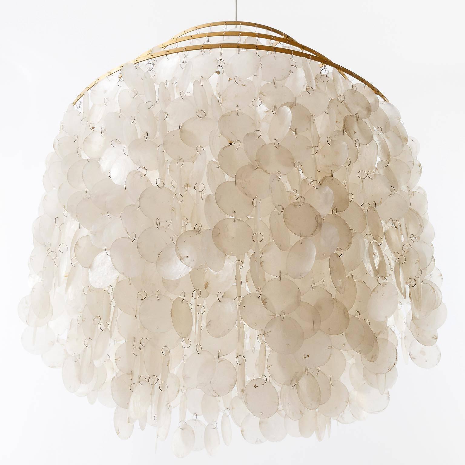 An impressive three-tier sea shell chandelier / pendant light designed by Verner Panton for the Swiss manufacturer J. Luber Ag. An original vintage piece manufactured in Mid-Century (1960s-1970s).
Hundreds of sea shells are hanging on three rings