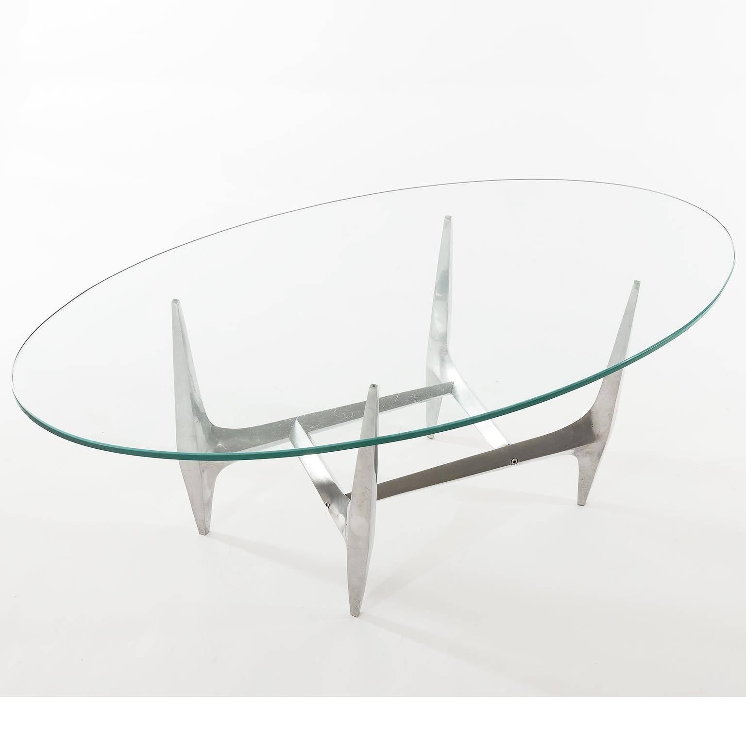 A sculptural coffee or cocktail table by Knut Hesterberg manufactured by Ronald Schmitt, Germany, in Mid-Century at the end of 1960s and the beginning of 1970s.
An oval glass is placed on a polished aluminum base.

Original vintage condition with