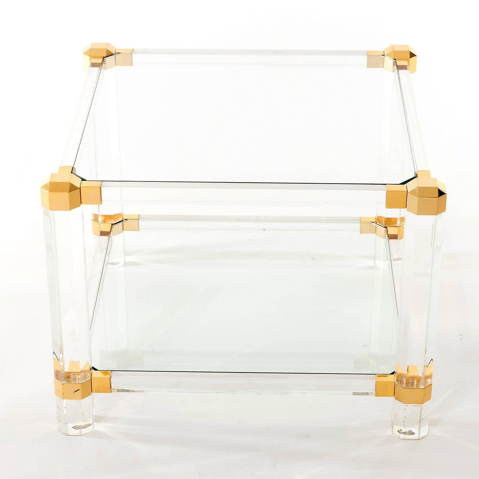 A cocktail or side table in the style of Pierre Vandel, Paris, France, manufactured in Mid-Century in 1970s. It is made of Lucite, glass and gilded parts.
Excellent condition.