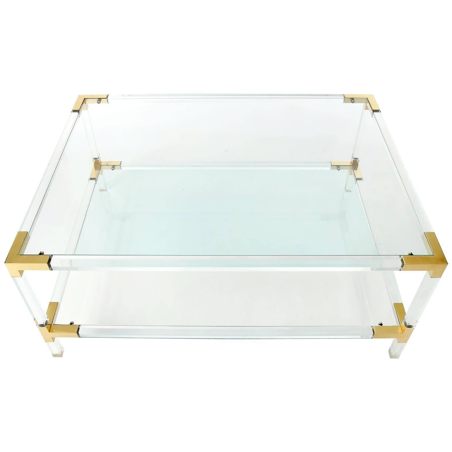A large Italian Hollywood Regency coffee or cocktail table with two glass shelves attributed to Romeo Rega and in the Style of Charles Hollis or Maison Jansen, manufactured in Mid-Century in 1970s. The glasses are removable and the frame is made of