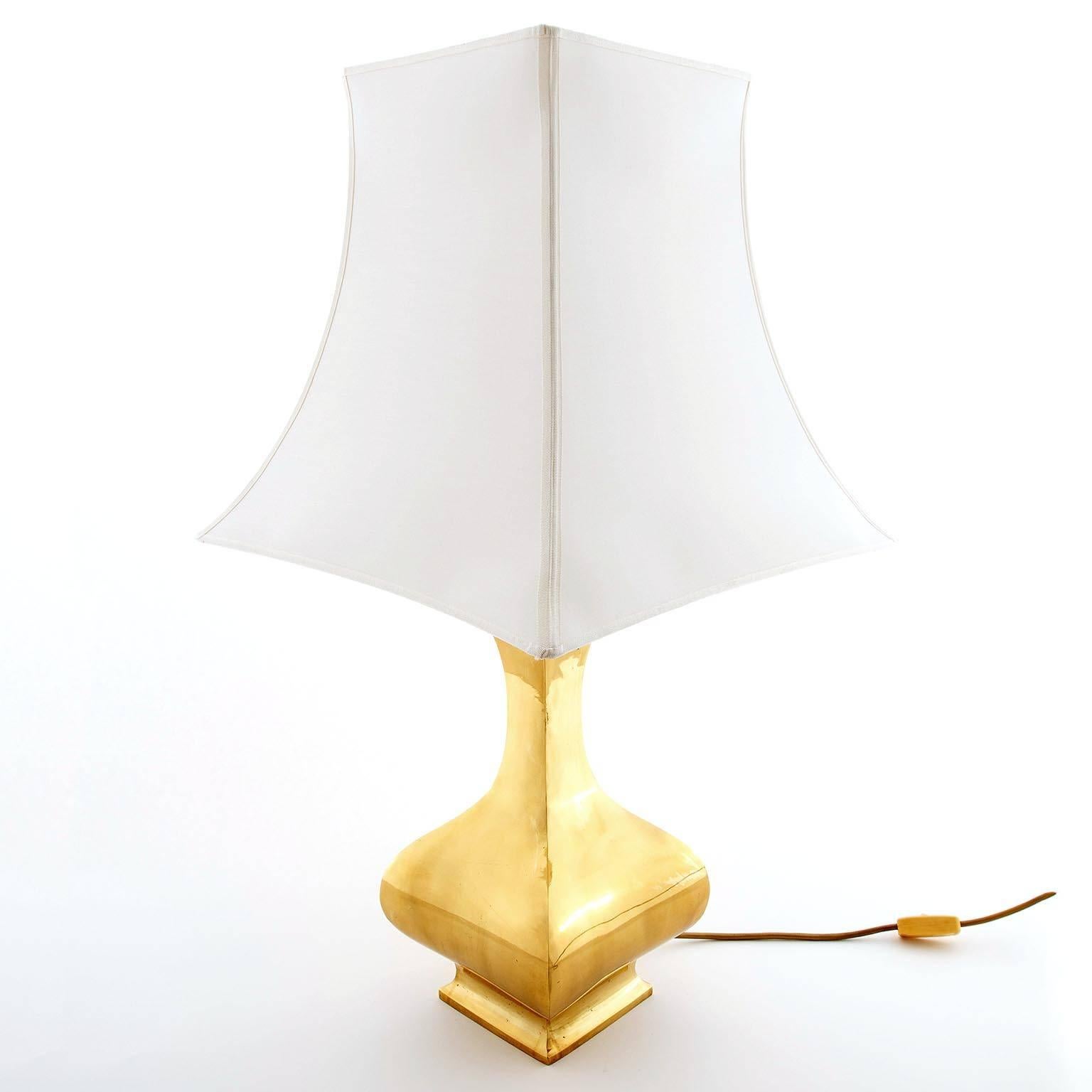 A large table lamp by French designer Maria Pergay, manufactured in Mid-Century, circa 1970. A polished solid brass stand with a newly refurbished white pagoda shaped lampshade.

It takes one medium screw base bulb.

These lights were used in the