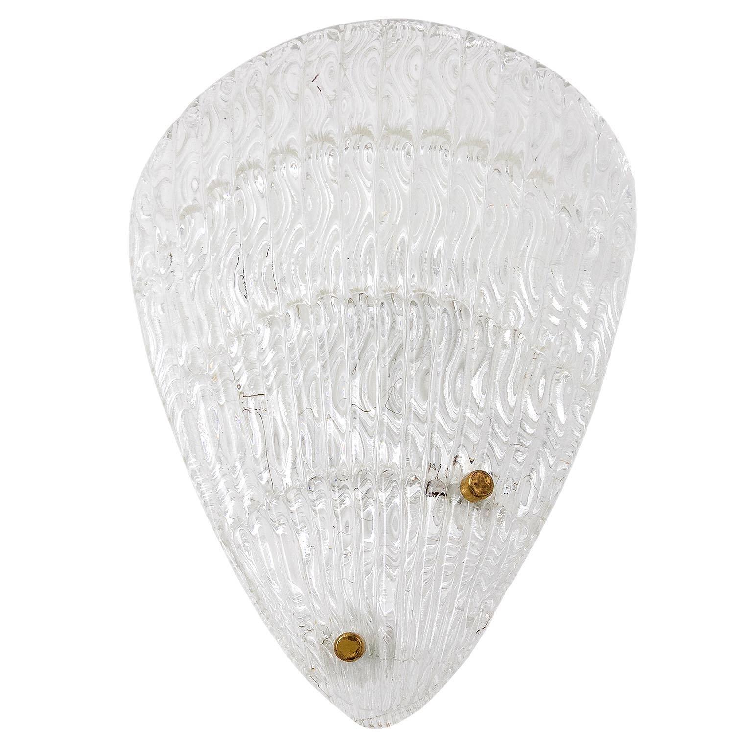 One of three large shell shaped glass sconces by Rupert Nikoll, Austria, manufactured in Mid-Century, circa 1950 (late 1950s or early 1960s).
An organic shaped glass piece is mounted with brass bolts on a white painted metal backplate.
The textured