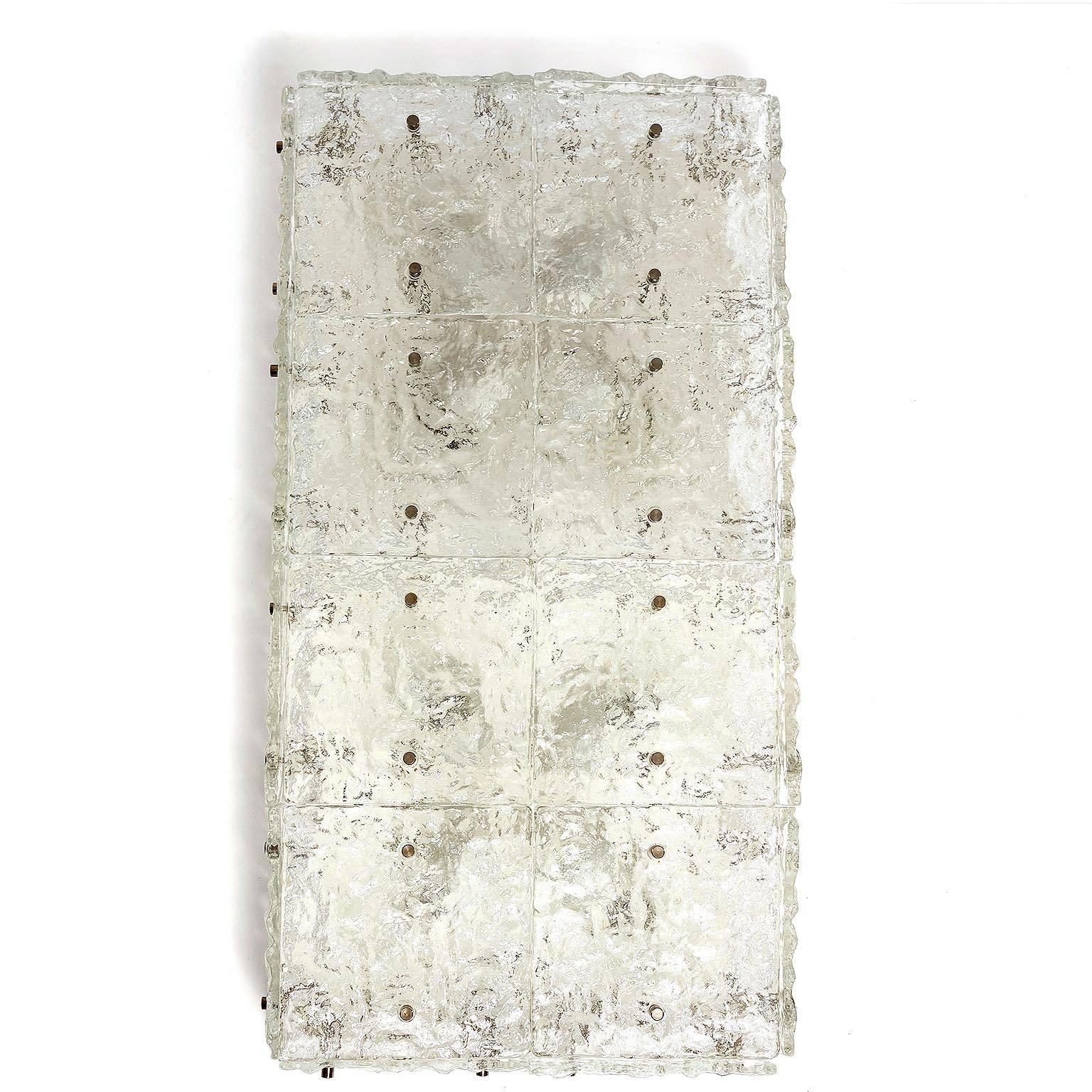 A large flush mount or wall light fixture modell 'Dachstein' by Kalmar, Austria, manufactured in Mid-Century, circa 1970 (late 1960s and early 1970s). 
Frosted and textured glass elements are mounted with chrome or nickel bolts on a white metal
