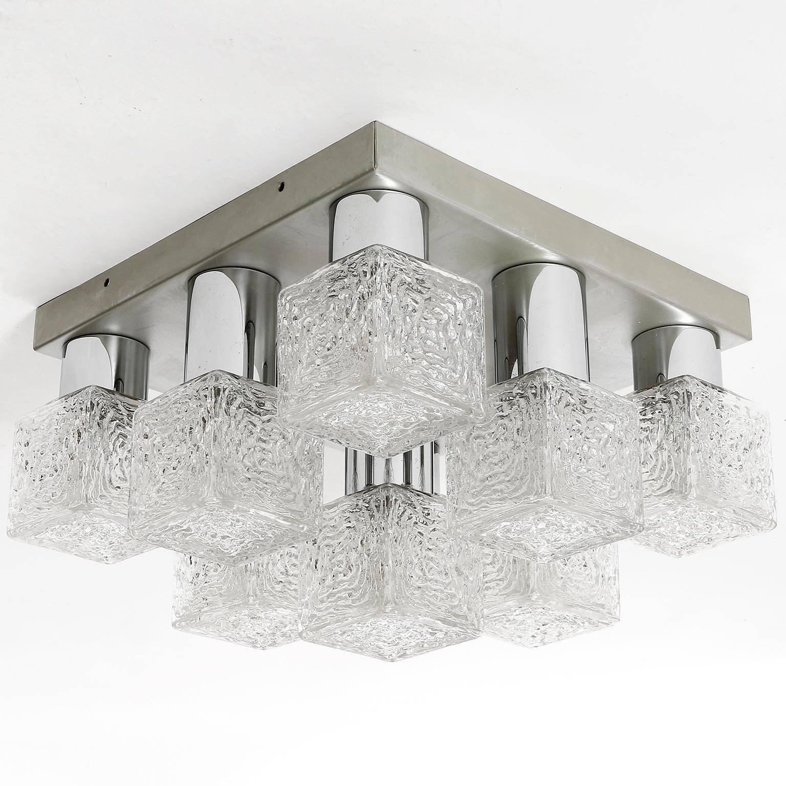 One of two German flush mount ceiling lights or sconces manufactured in Mid-Century, circa 1970 (late 1960s or early 1970s). 
They are made of a silver painted metal backplate with nine chrome stands for lampshades in the form of frosted ice glass