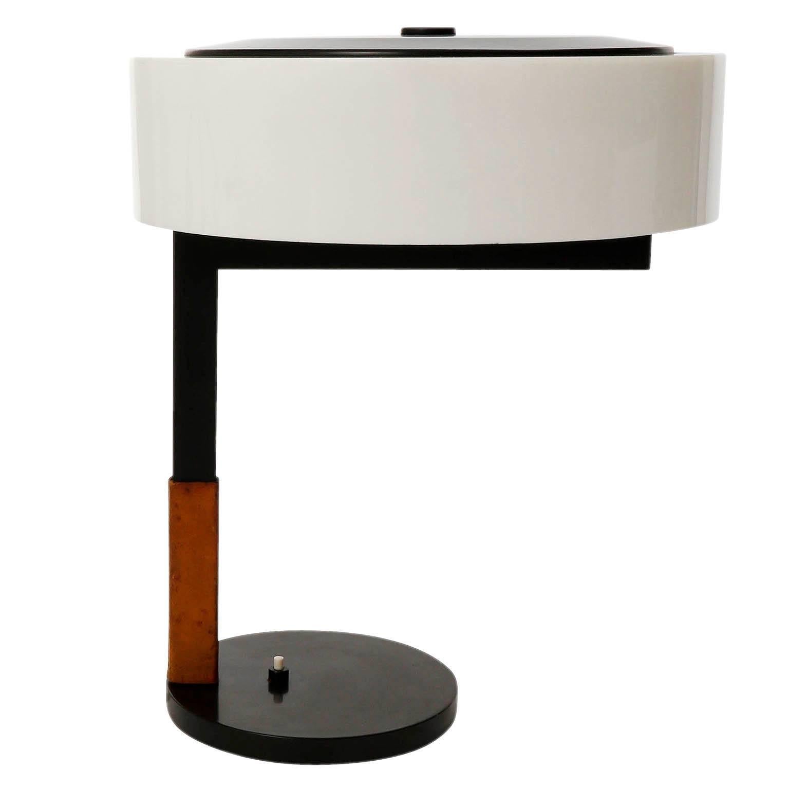 One of two table or desk lights model 'ASSISTENT' (no. 1277) by J.T. Kalmar, Austria, manufactured in Mid-Century in the late 60s.
They are made of a blackened iron stand with a brown leather handle. The swiveling lampshade is made of an opal white