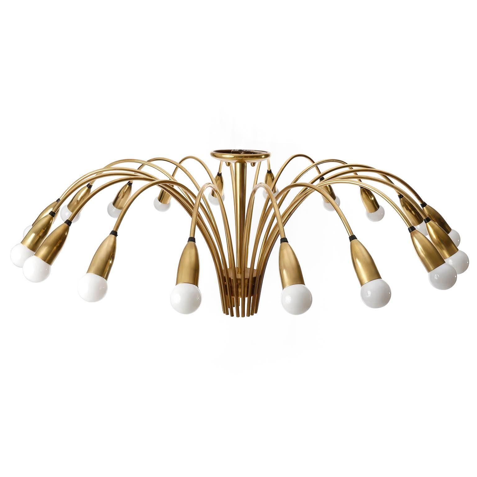 An extra-large spider or Sputnik flush mount light fixture made of polished brass. This huge 18 arm lamp is in the style of Stilnovo and was manufactured in Italy or German in Mid-Century, circa 1960 (late 1950s or early 1960s). 
The light has 18