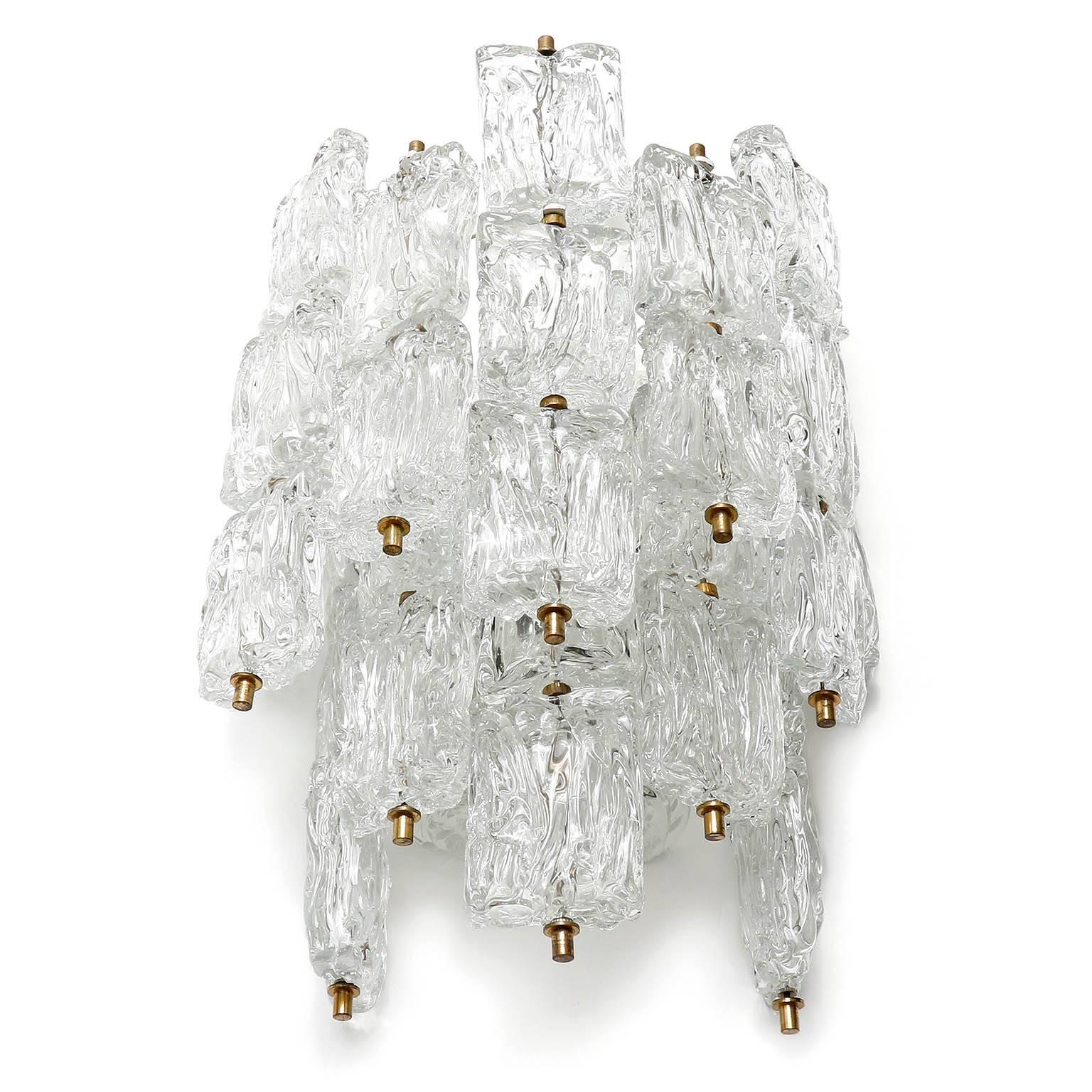 A large textured glass wall lamp manufactured by Vereinigte Werkstätten München, Germany, in Mid-Century, circa 1960. 
Several glasses are hung on a white enameled metal frame with brass hardware.
The glass is attributed to Aureliano Toso, circa