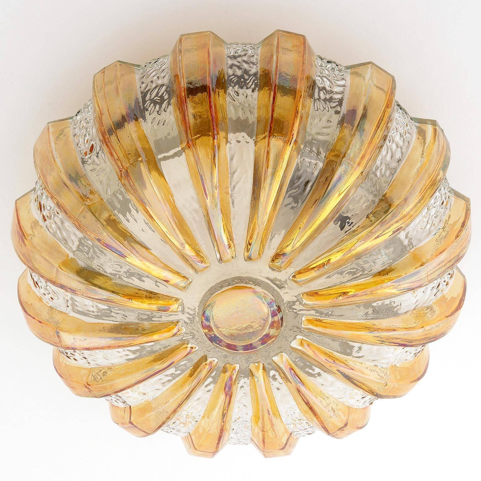 A nice flush mount light or sconce, manufactured in Germany in Mid-Century, circa 1970 (late 1960s to early 1970s). 
A round glass shade with orange / amber tone rays and a black lacquered circular backplate.
The lamp can be used as wall or