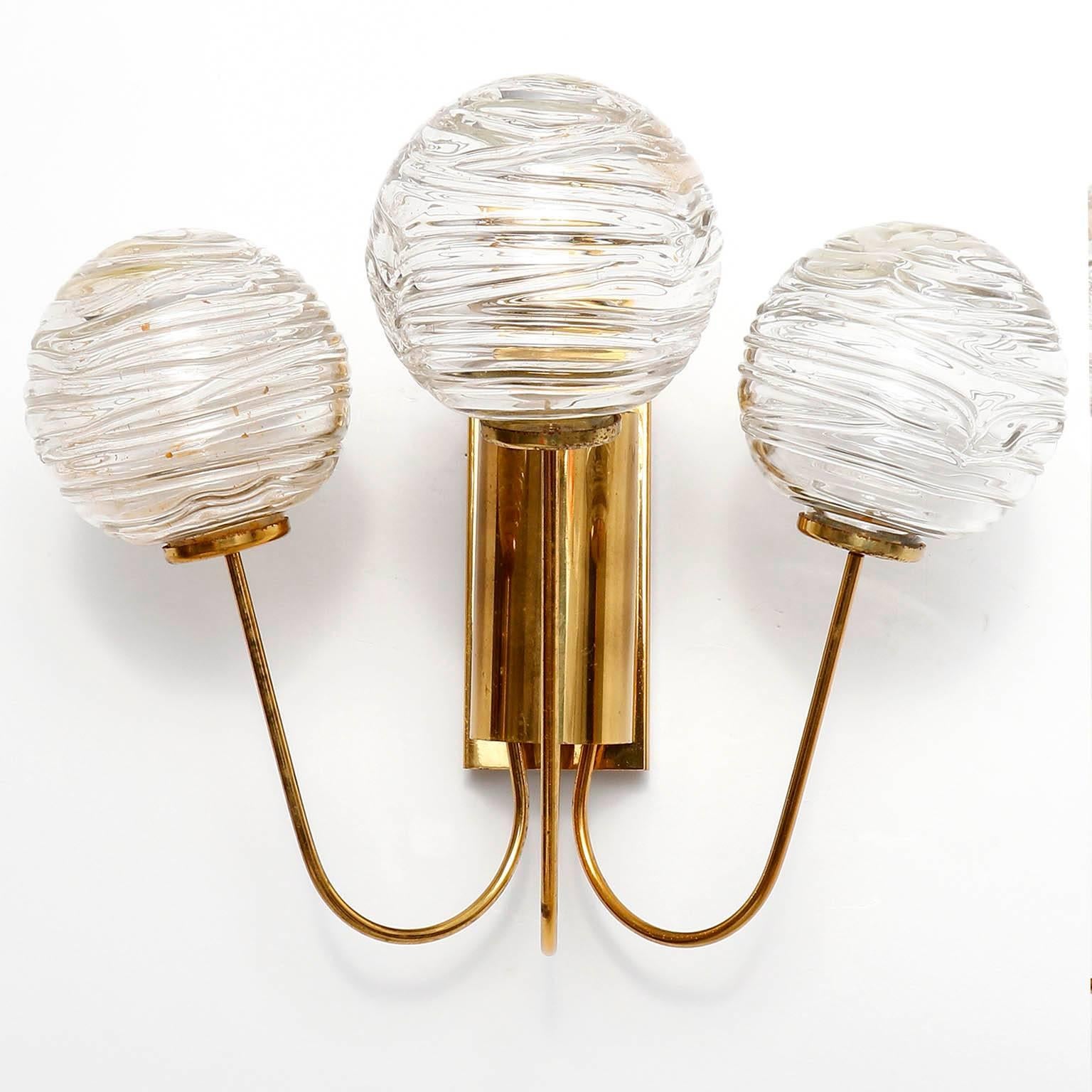 A pair of wall lamps by Doria Leuchten, Germany, manufactured in Mid-Century, circa 1960.
They are made of a brass frame which holds 3 hand blown glass balls with a diameter of 3.2