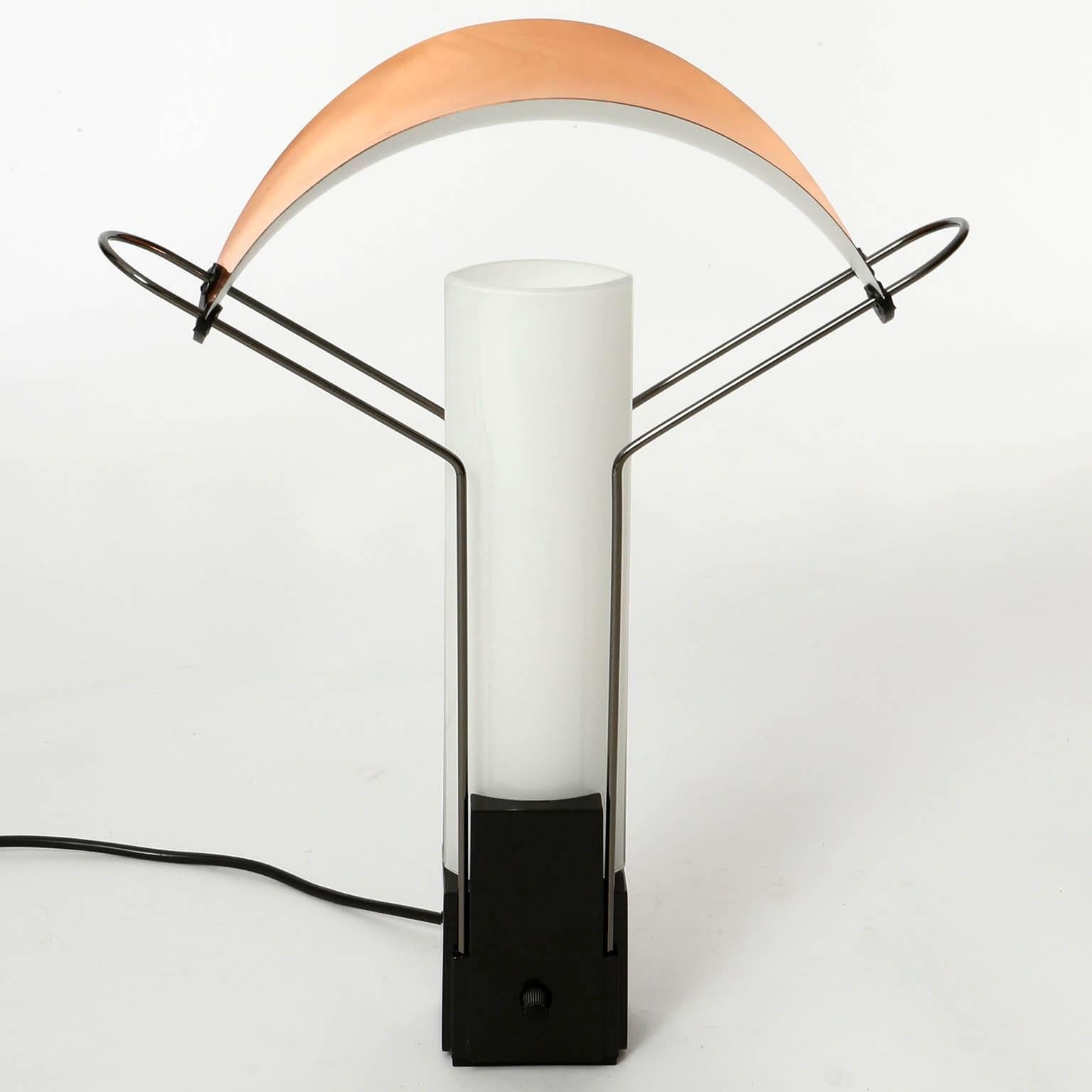 An Italian table lamp model 'Palio' designed by Perry A. King & Santiago Miranda, manufactured by Arteluce, Italy, 1985. It is marked at the bottom.
The light has a black enameled metal base with chrome wires which hold a copper lamp shade. Two