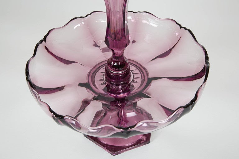 An amethyst blown glass epergne or centrepiece. Antique, American last quarter of the 19th century. Featuring open vase at the top, ruffled edge and pedestal base.