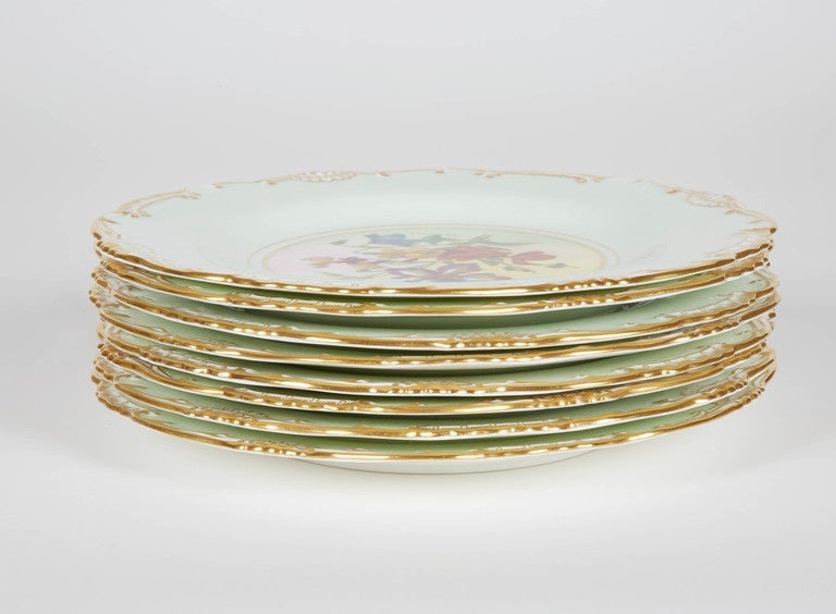 A set of eight dessert plates. Minton England. Vintage, circa 1950. Hand-painted florals on a mint green background, shaped plate and hand trimmed 24-karat gold. Measures: 9