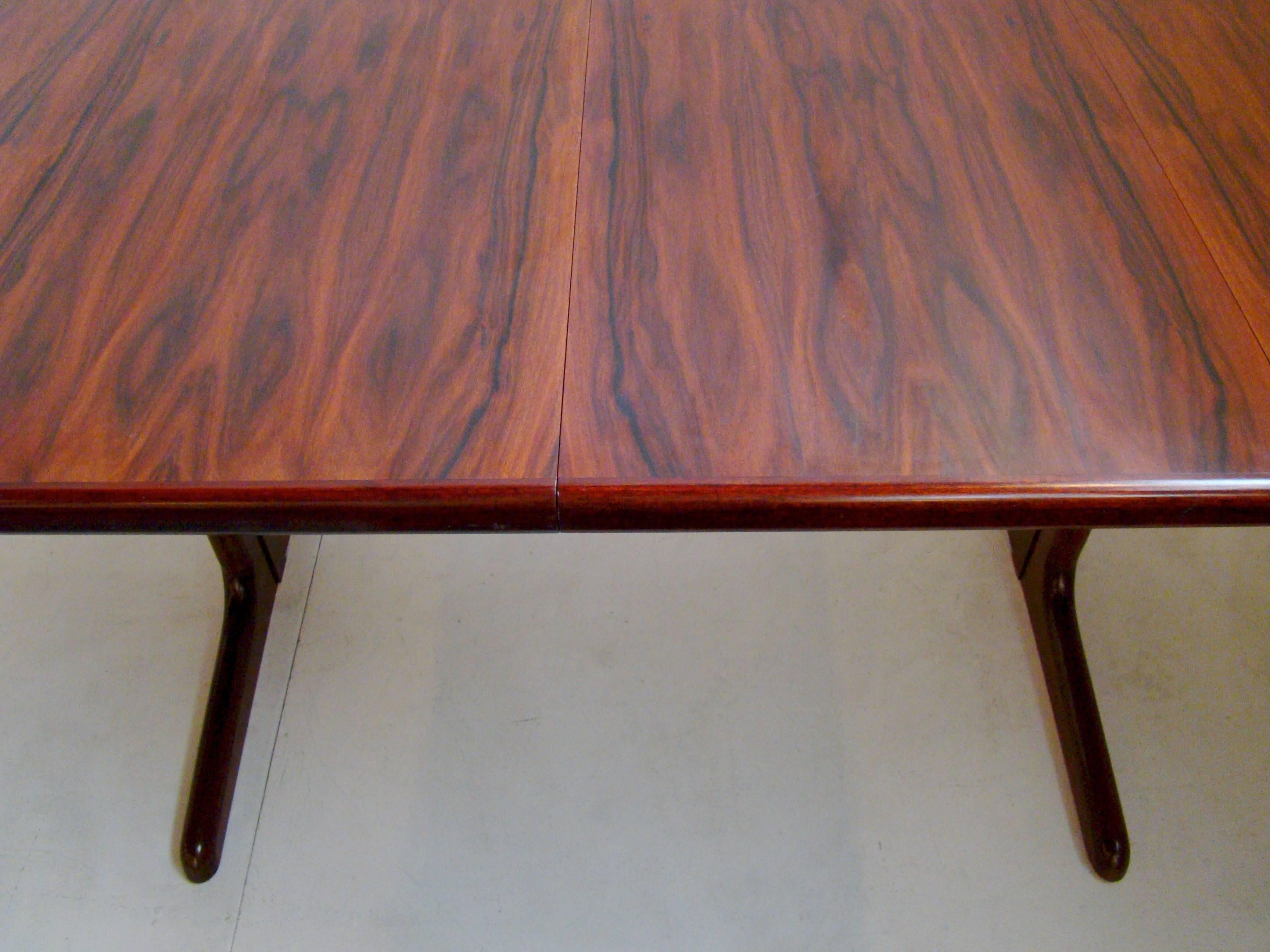 Fine, narrow, extension dining table (plus two leafs) in rosewood veneers and solids. shows only light wear and minimal use. Beautiful grain. Table measures approximately 40' x 65