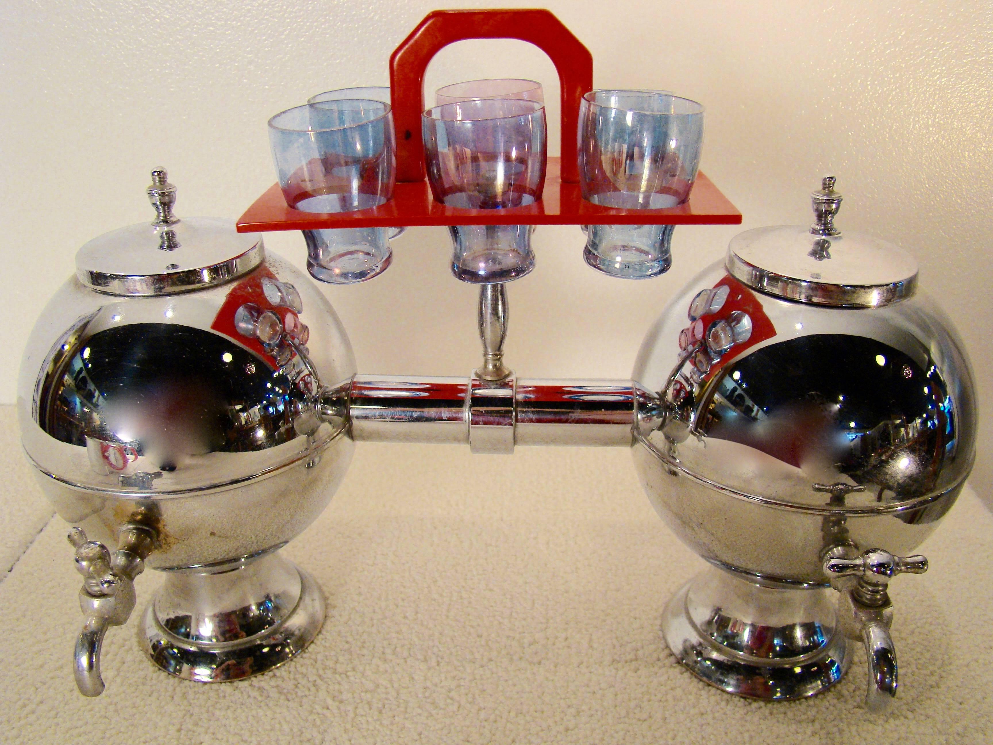 Double orb chrome liquor dispenser with six glass shot glasses that sit in a bakelite holder, circa 1940s. Marked chromium on the bottom of decanter. Rare and stunning piece. Two spun aluminium mugs with bakelite handles stamped Hannah Porter New