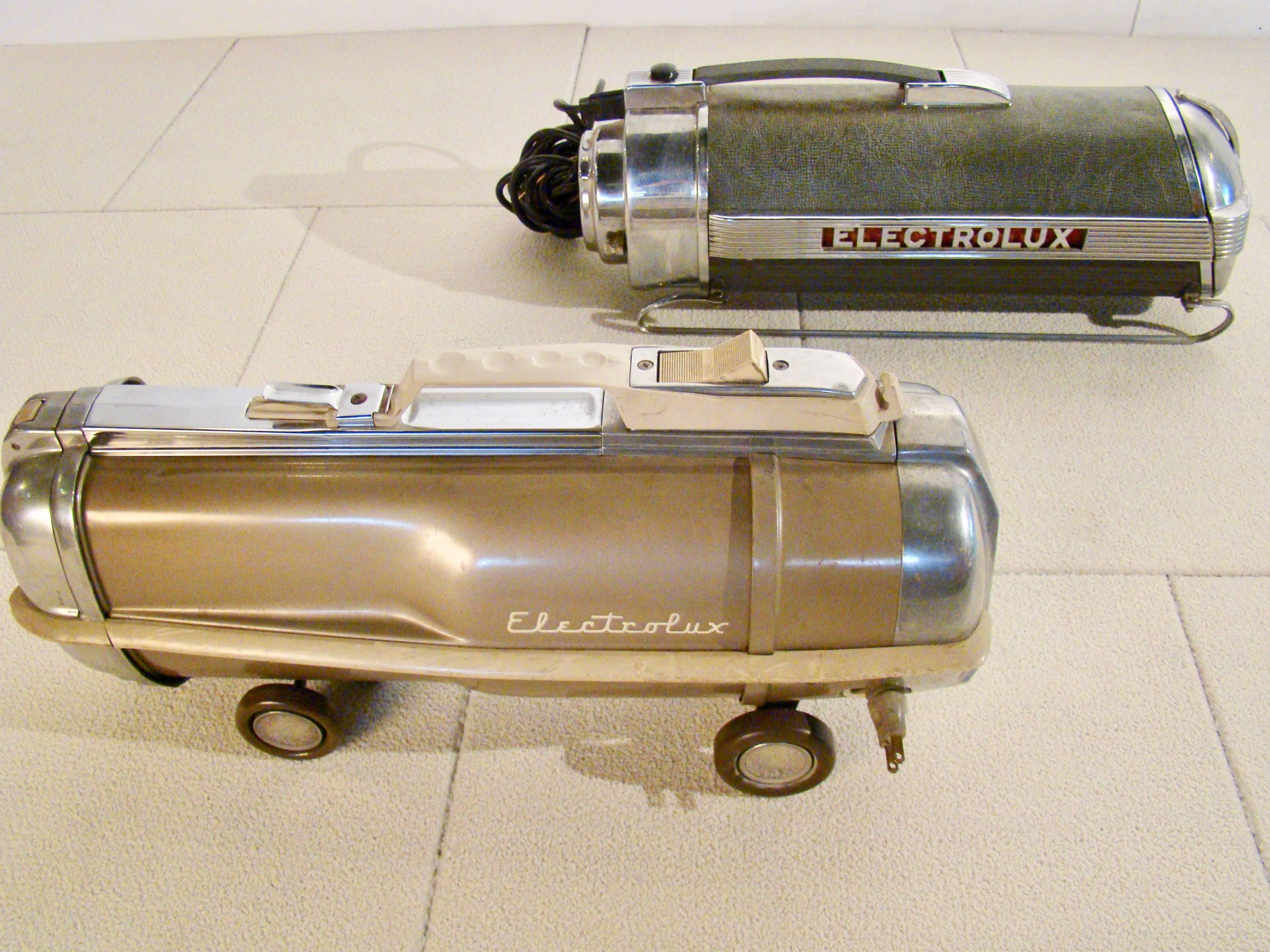 Pair of Machine Age vacuums by Electrolux. In the forefront is Electrolux models 30. The sled base and horizontal speed lines and plating create the illusion of perpetual motion. This model was designed by Industrial legend Lurelle Guild in 1937 and