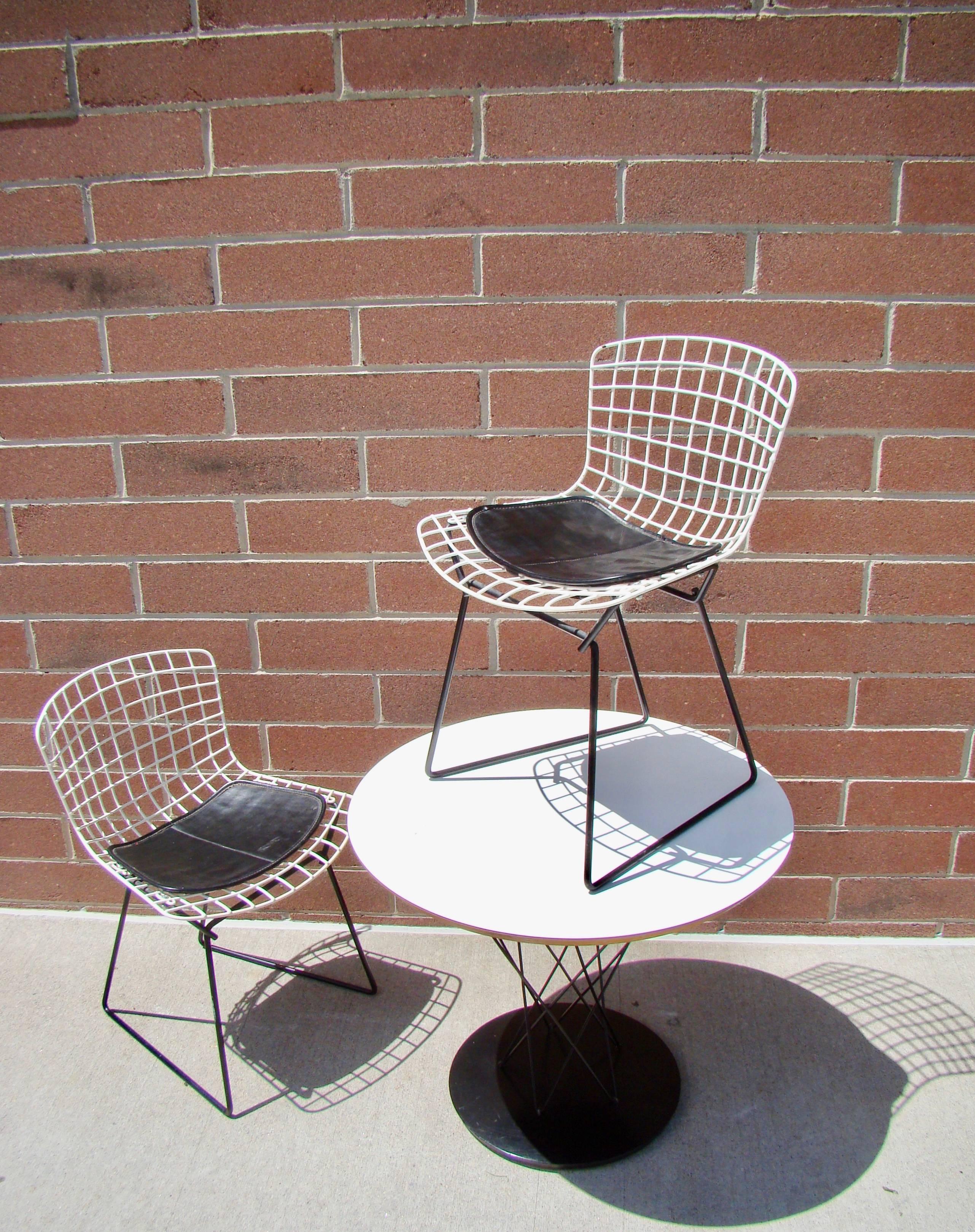 Early Noguchi cyclone table and Bertoia chairs with the original seat pads designed for Knoll. The cyclone table was originally designed as a child's table but is more commonly used as a side table. Table is marked with the Knoll sticker and is