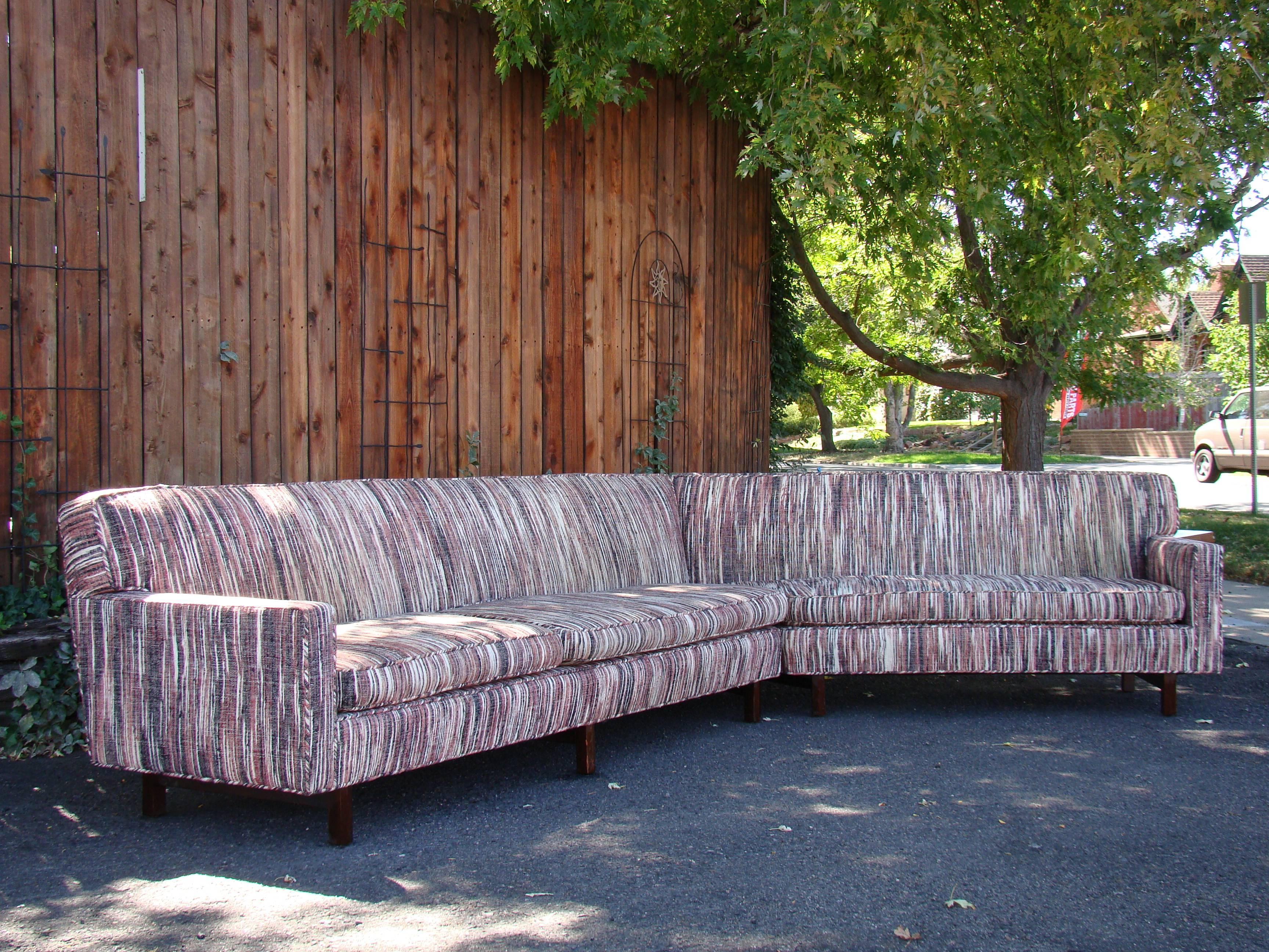 Large two-piece sectional sofa divides to the right of centre with a 45-degree angle. Left arm-facing sofa measures 110