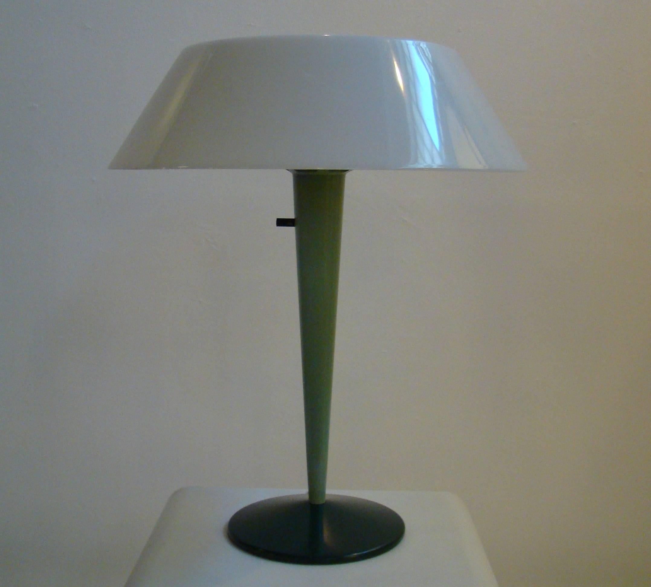 This lamp is uncommon in form and color. The metal base (finished in dark forest green) contrasts the conical stem (in light forest service green) . The two-part frosted plastic shade is topped by a white metal difuser. It is stunning when