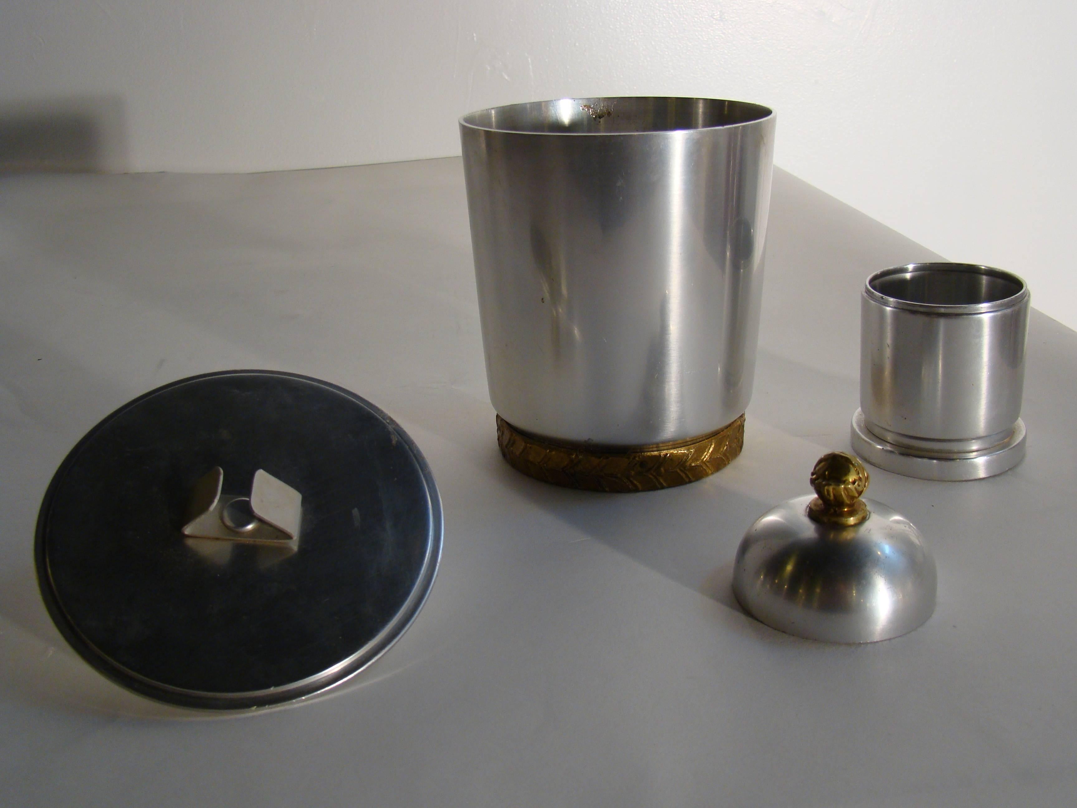 Famed industrial designer Lurelle Guild designed these pieces for the Kensington aluminum ware company in the 1930s.  The set consists of a cigar humidor trimmed in brass and complete with the sponge clip inside the top, and the cigarette holder
