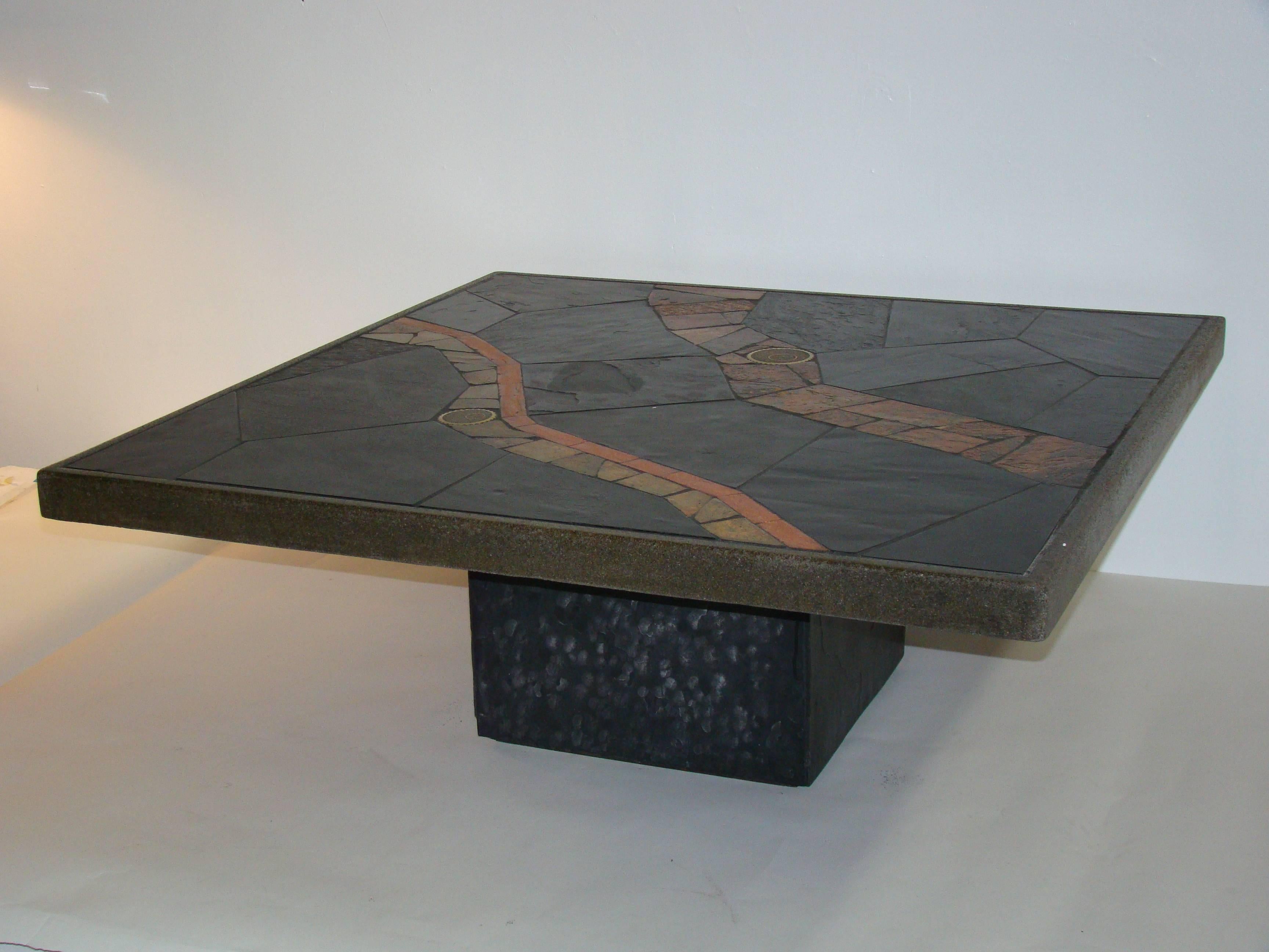An organic assemblage of richly colored African slate incorporating inlays of machined brass elements on a platform of moss stained concrete that rests on a square black slate base. Unsigned.