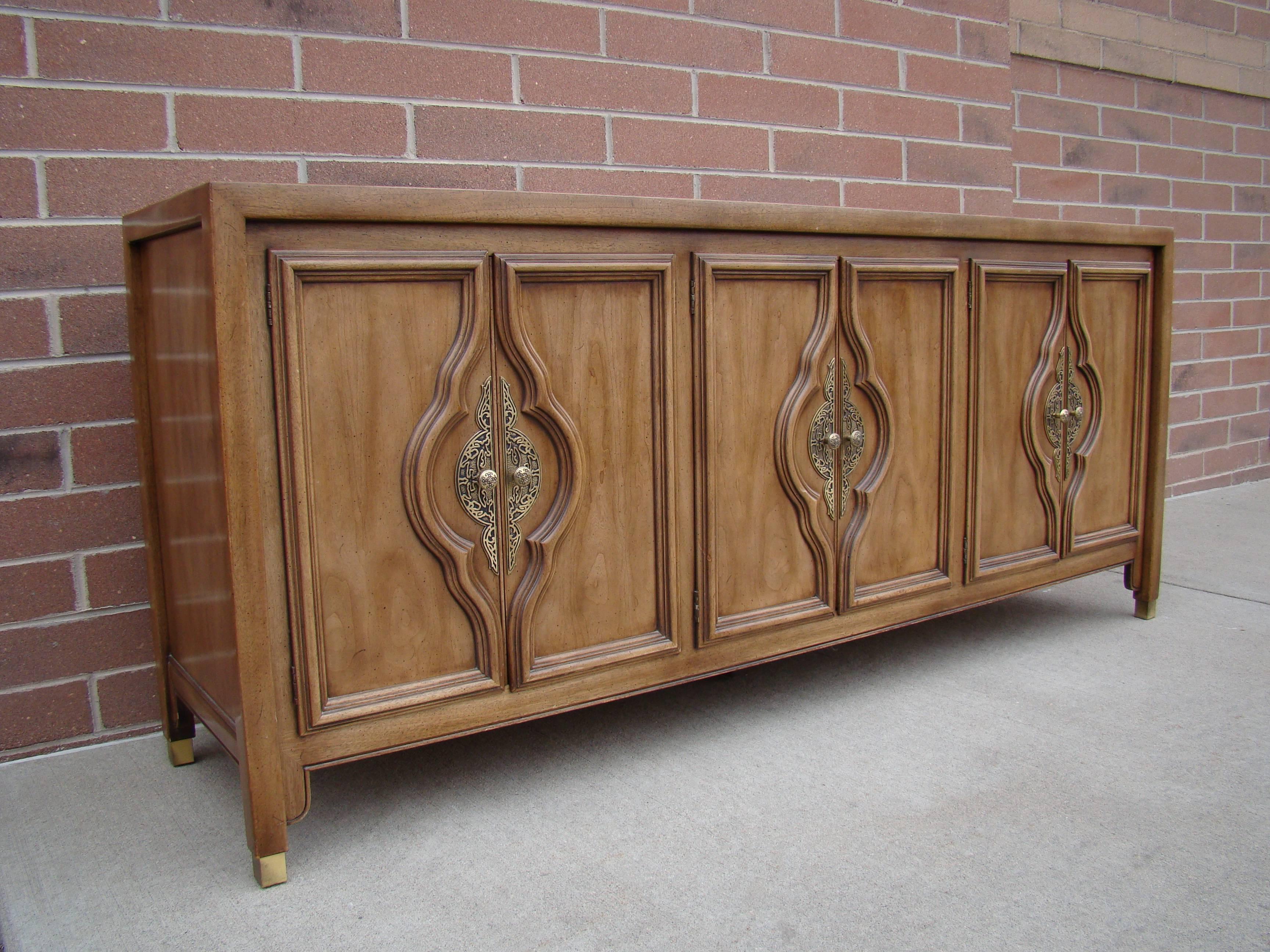 Beautiful Century Furniture credenza with brass detailing after James Mont, circa 1960s each side has shelves and the middle contains three drawers. Good vintage condition all around except for the top which has some wear and some water damage. A