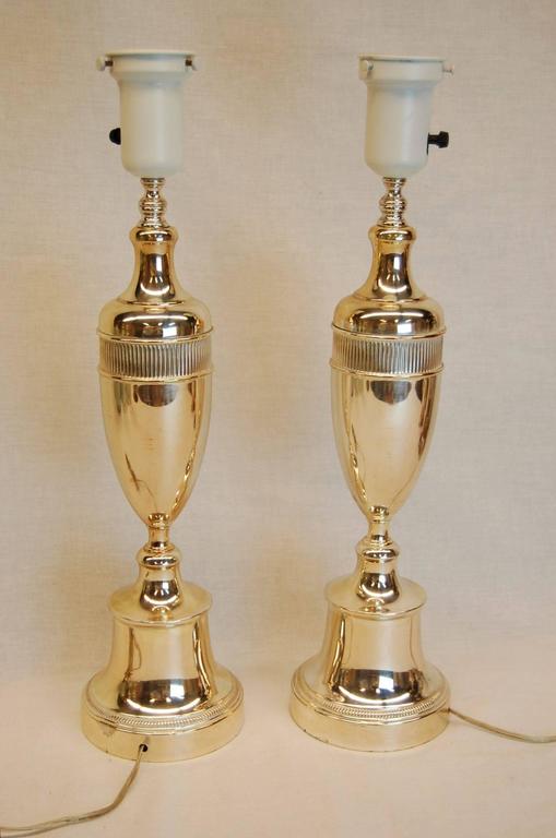 Pair of interestingly shaped plated urn lamps likely from the 1940s. Dimension to the top of the glass reflector bowl is 26.5 inches, 17.5 inches to the top of the silver urn. Three way sockets. 