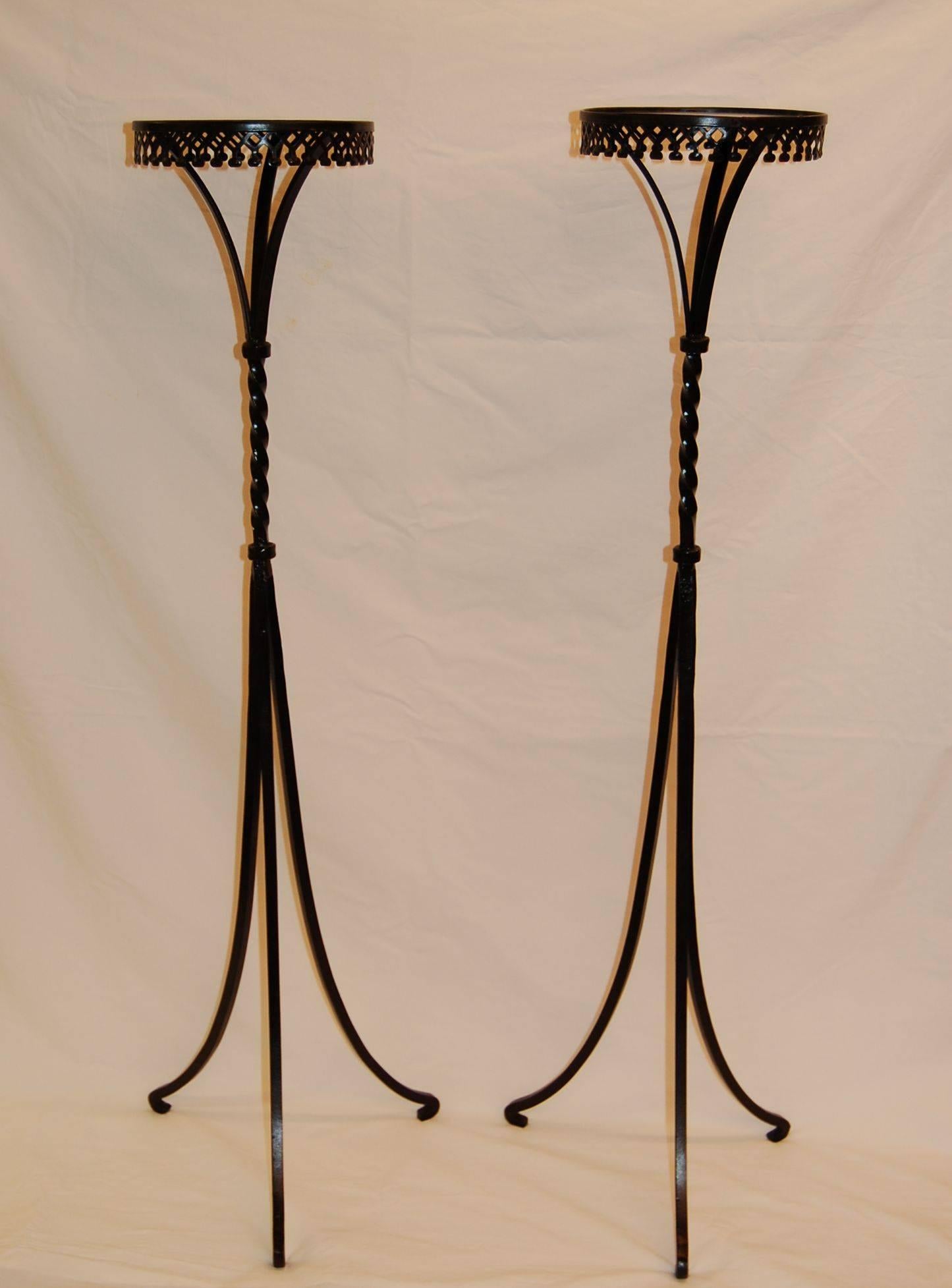Pair of iron plant stands or pedestals constructed of solid steel with decorative steel cut-out trim around the top edge.