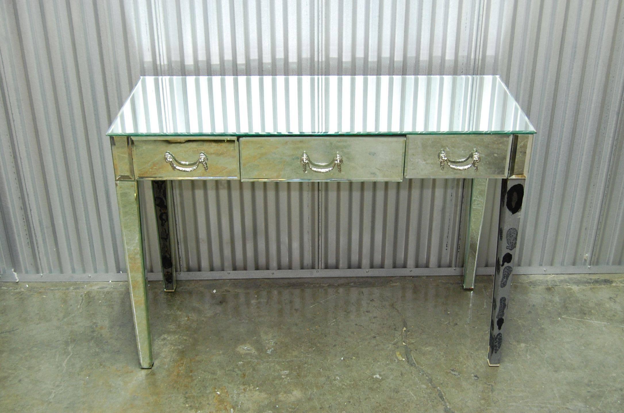 Classic looking mirrored writing table with three drawers.